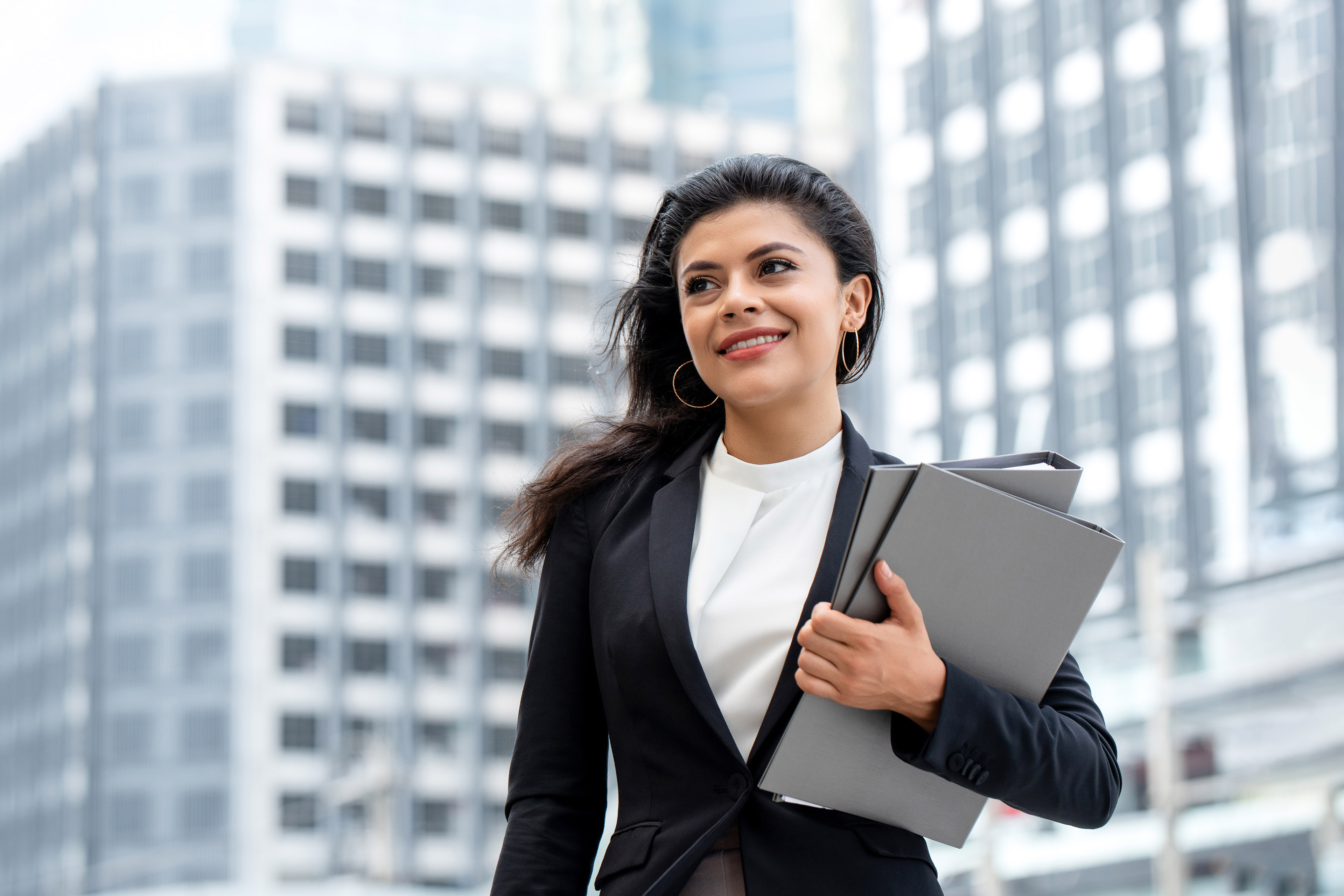 Young beautiful Latino businesswoman standing outdoors