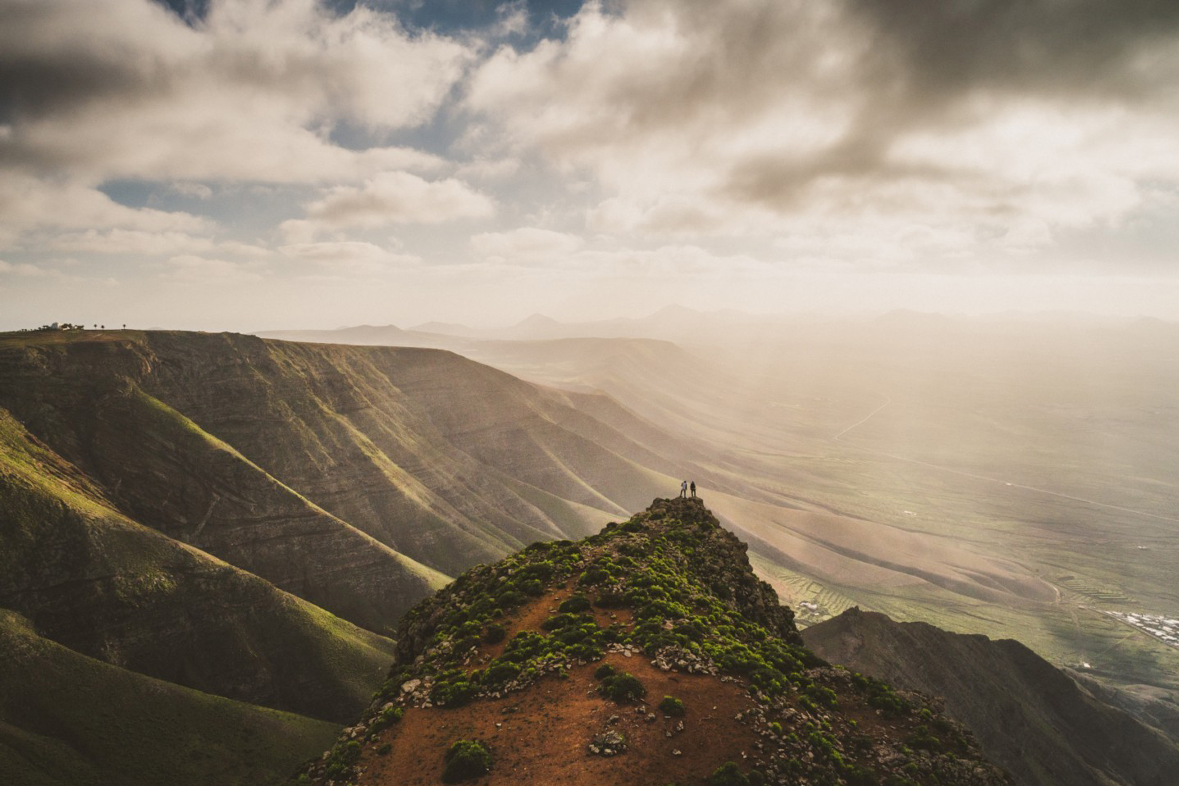 Two people standing on the edge of cliff