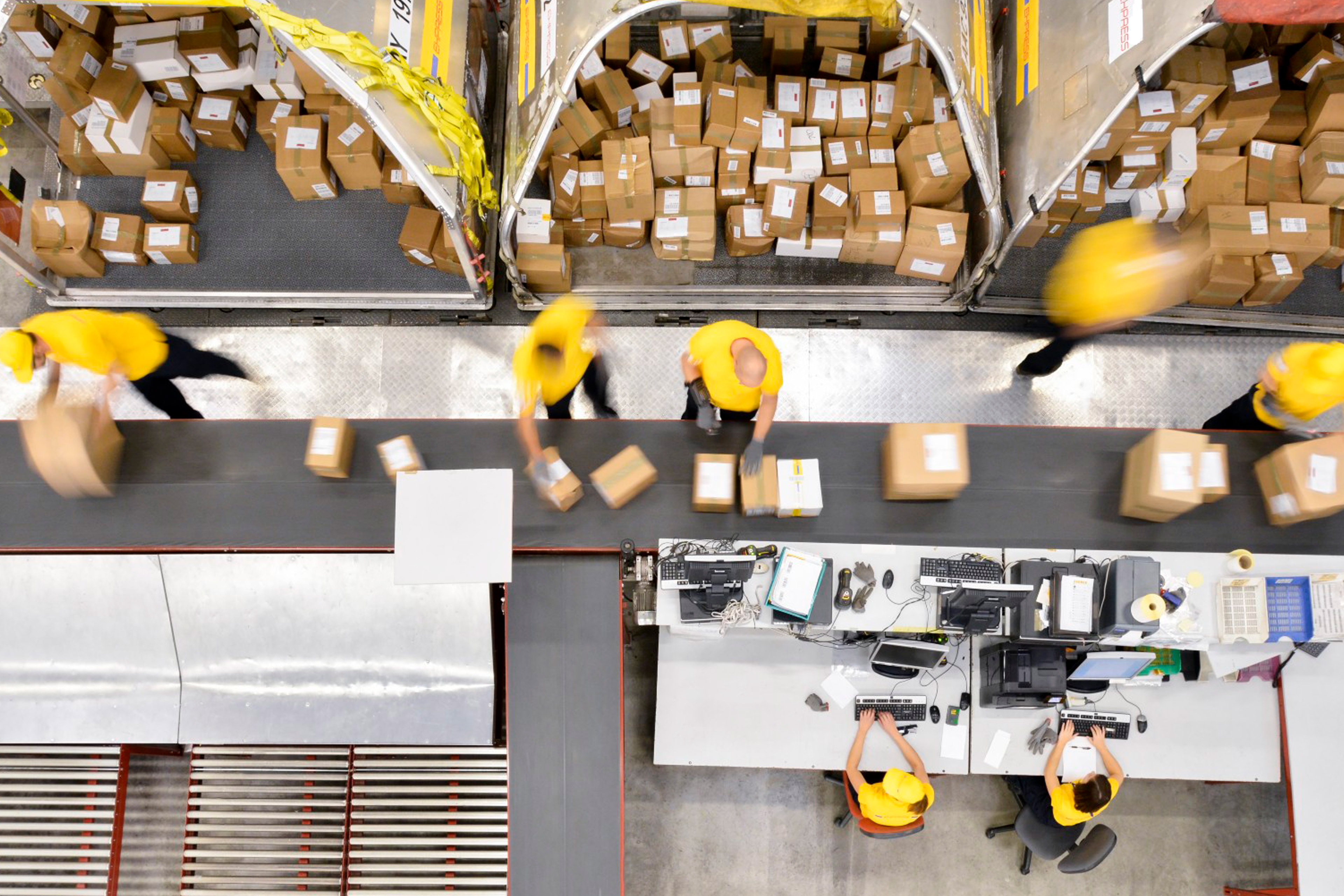 A group of people working in a warehouse packing and labeling boxes.