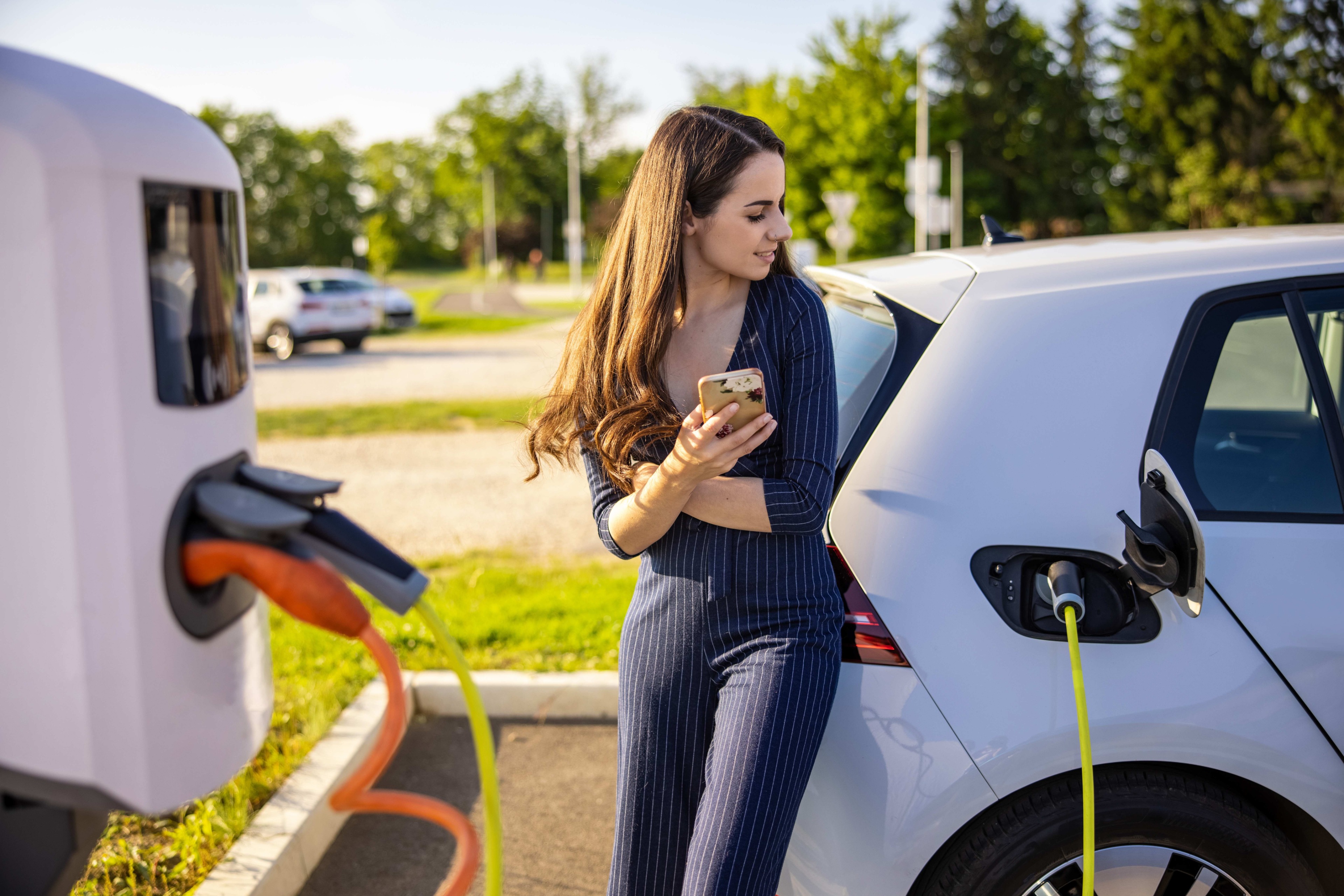 A woman charging an electric vehicle