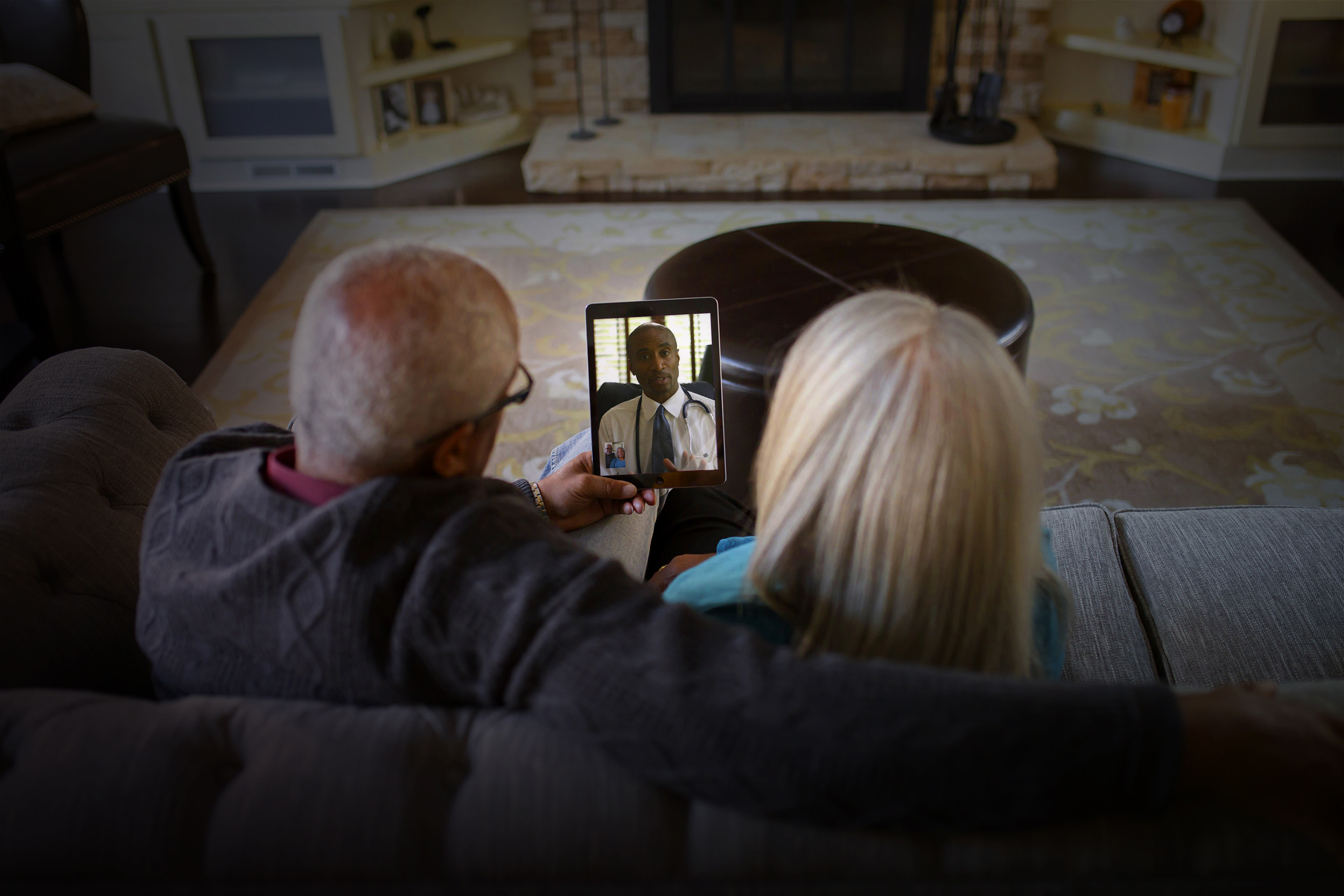 Mature couple video chatting to doctor on digital tablet