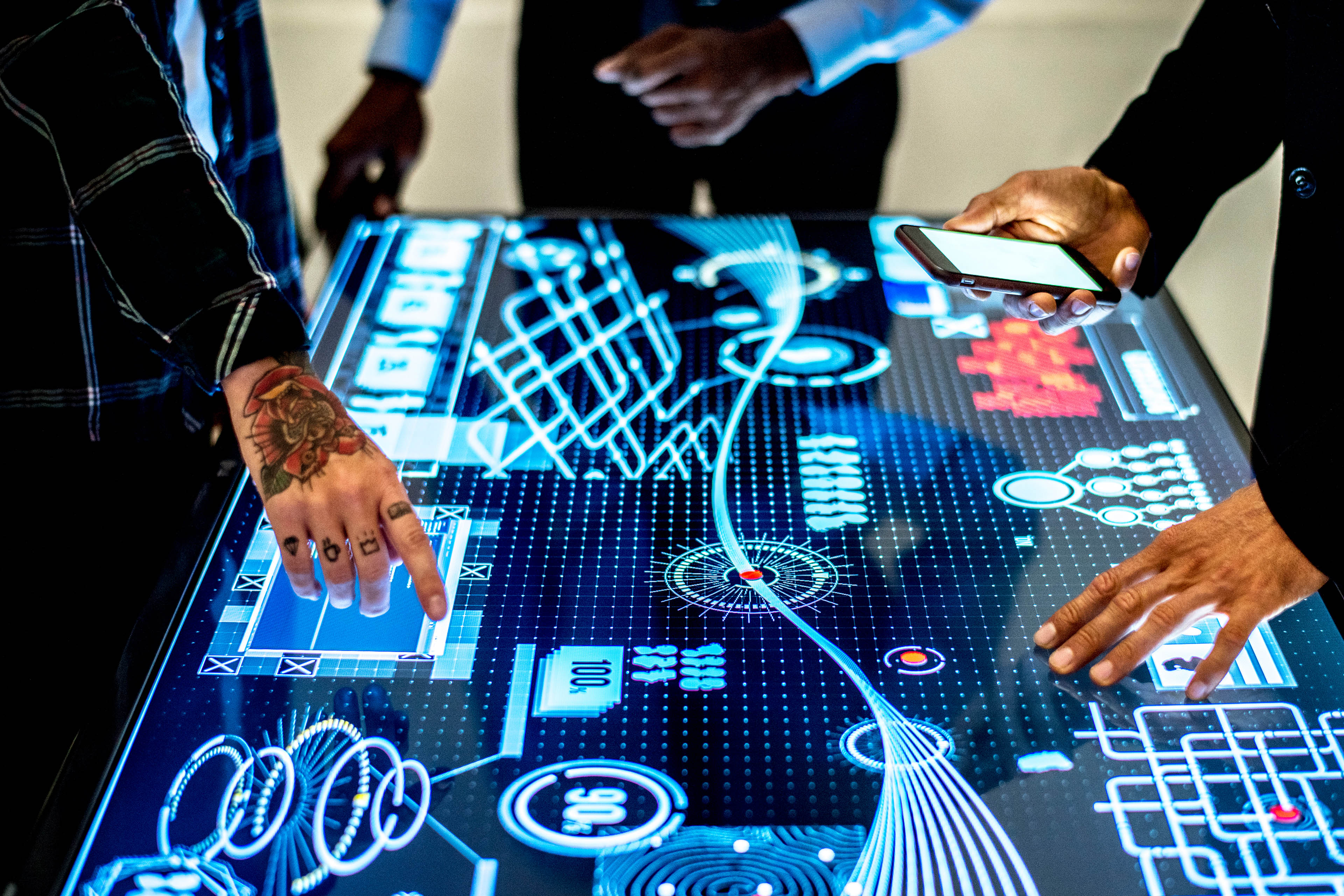 Men working around an interactive table-top display