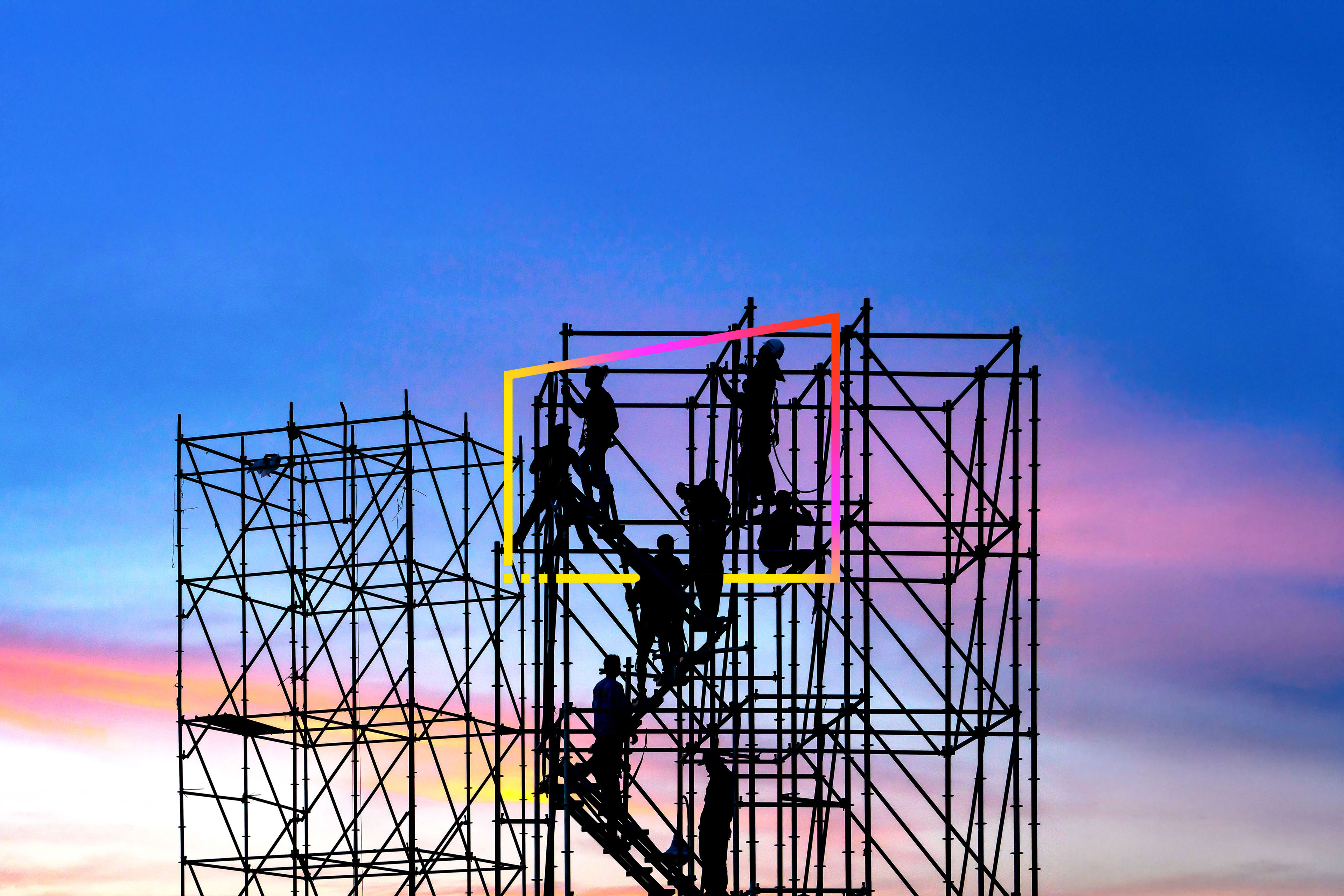 Engineers silhouetted on scaffolding at dusk