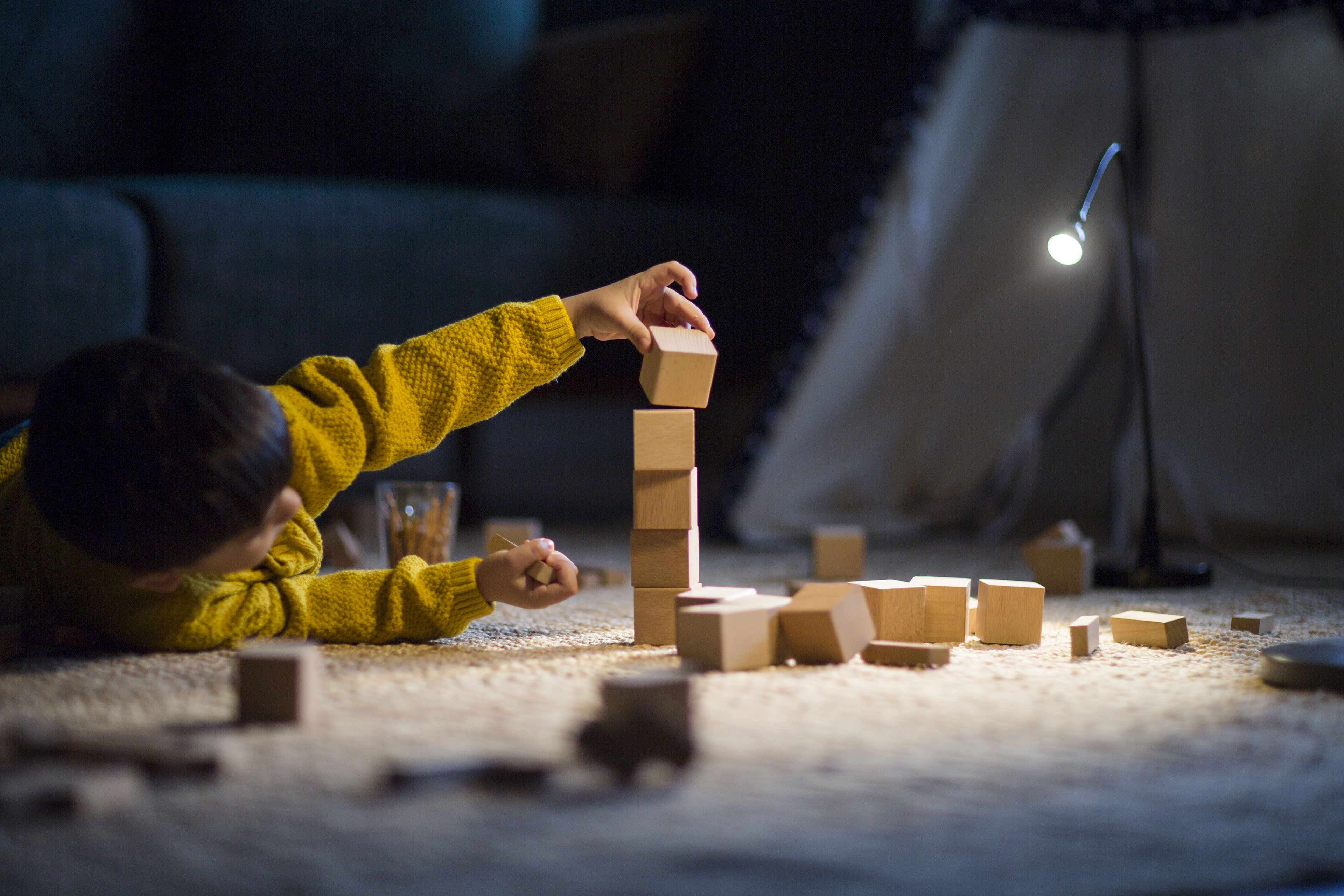 Boy playing with blocks on carpet