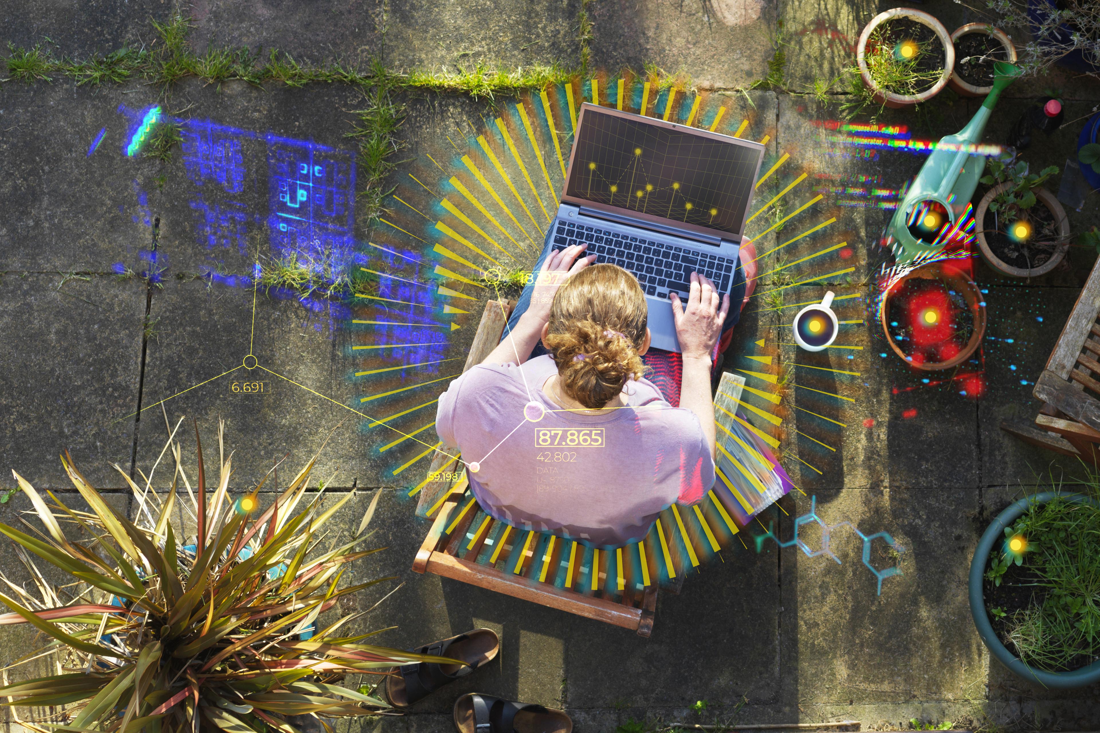 Elevated view of a woman working from home in her garden using a laptop computer