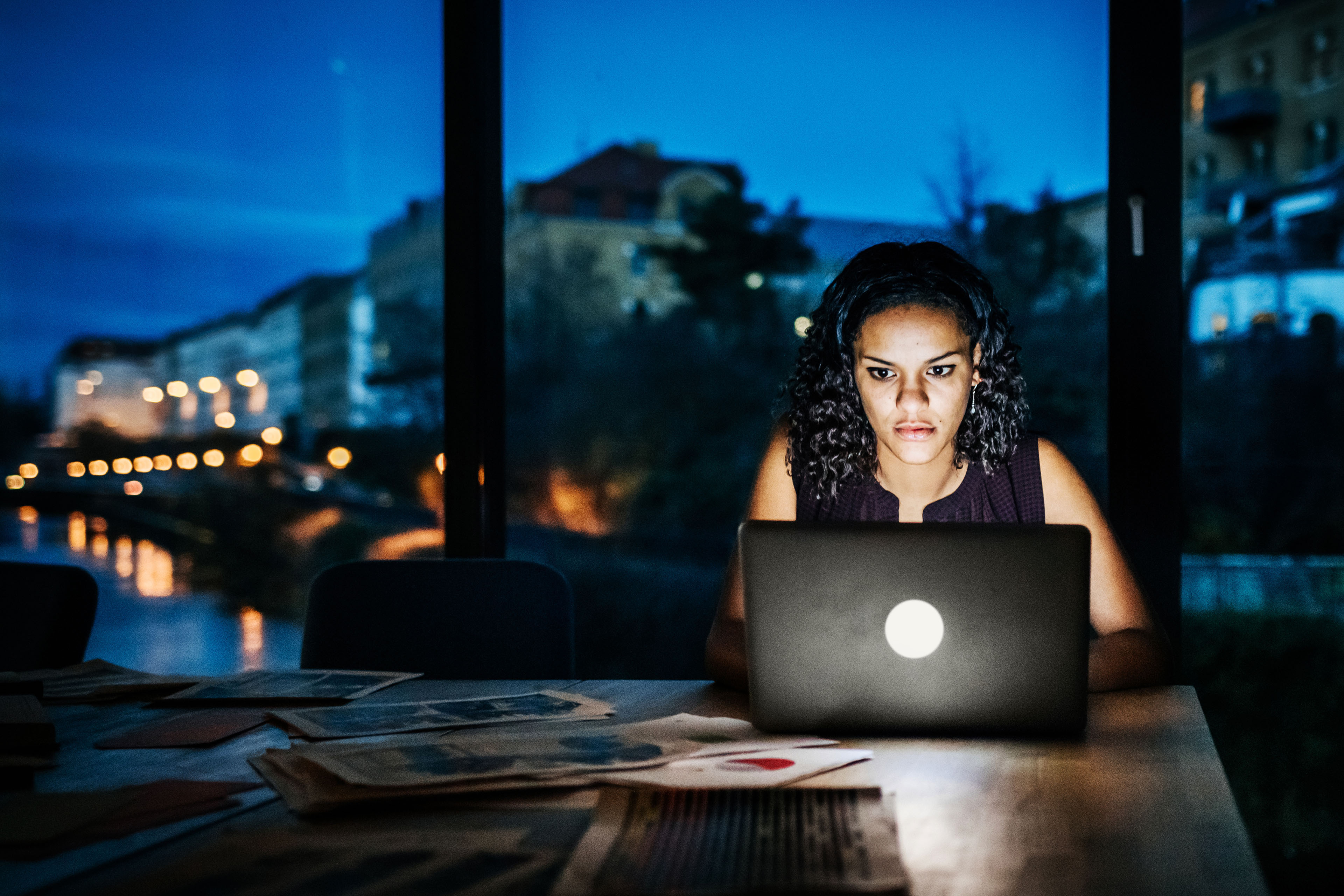 Casual young businesswoman working late on a laptop