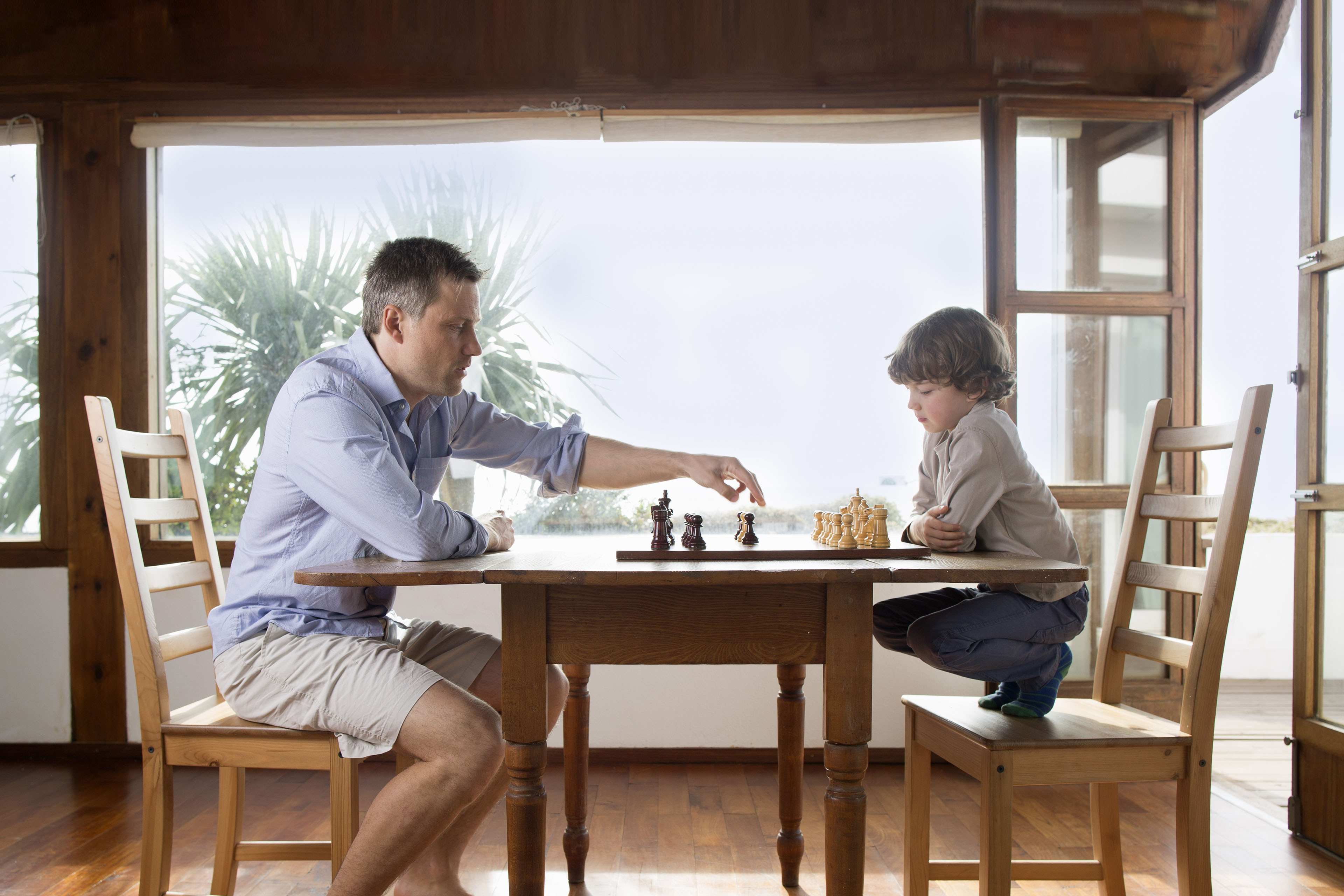 Dad and young son playing chess