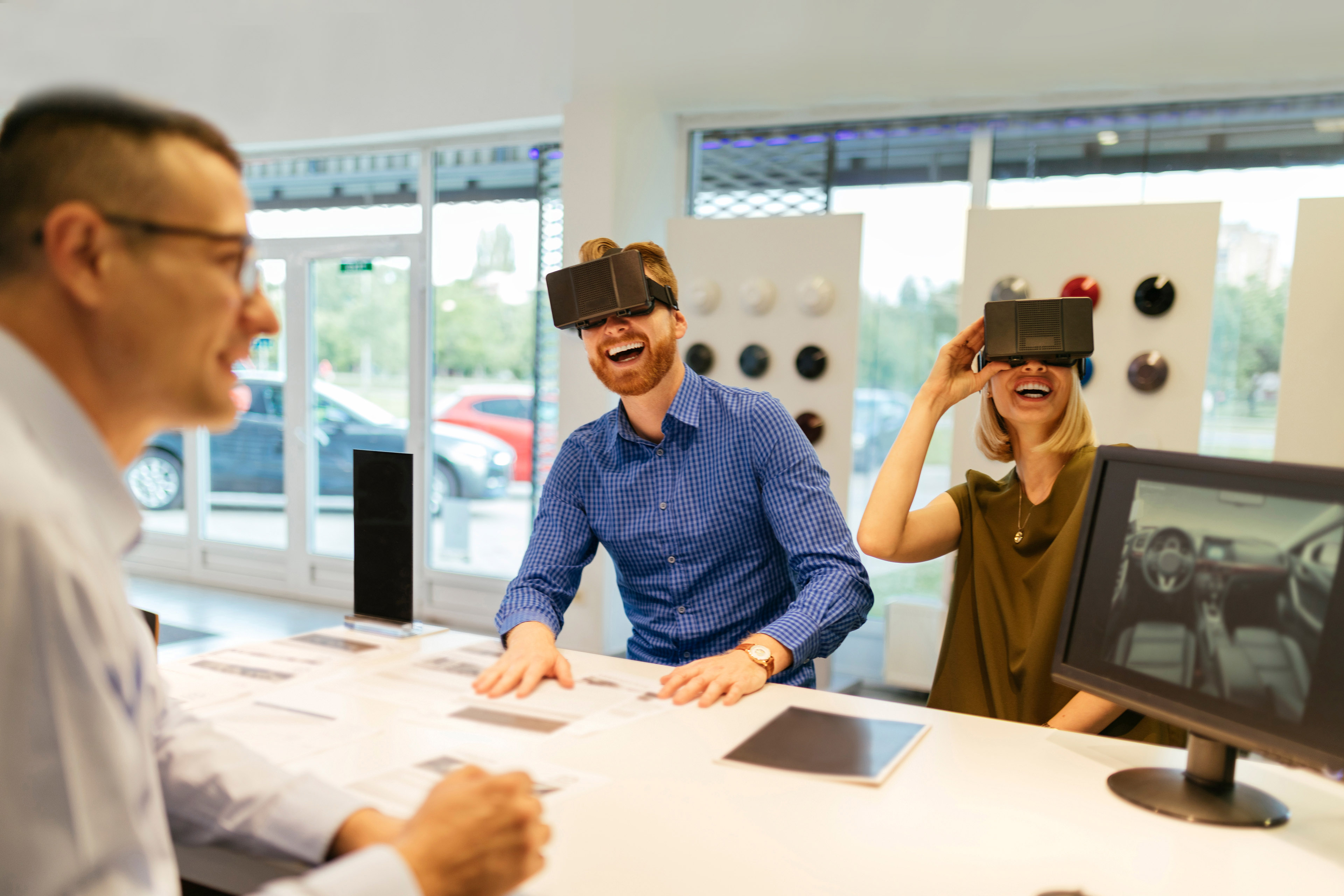 Couple using vr glasses in car dealership hero