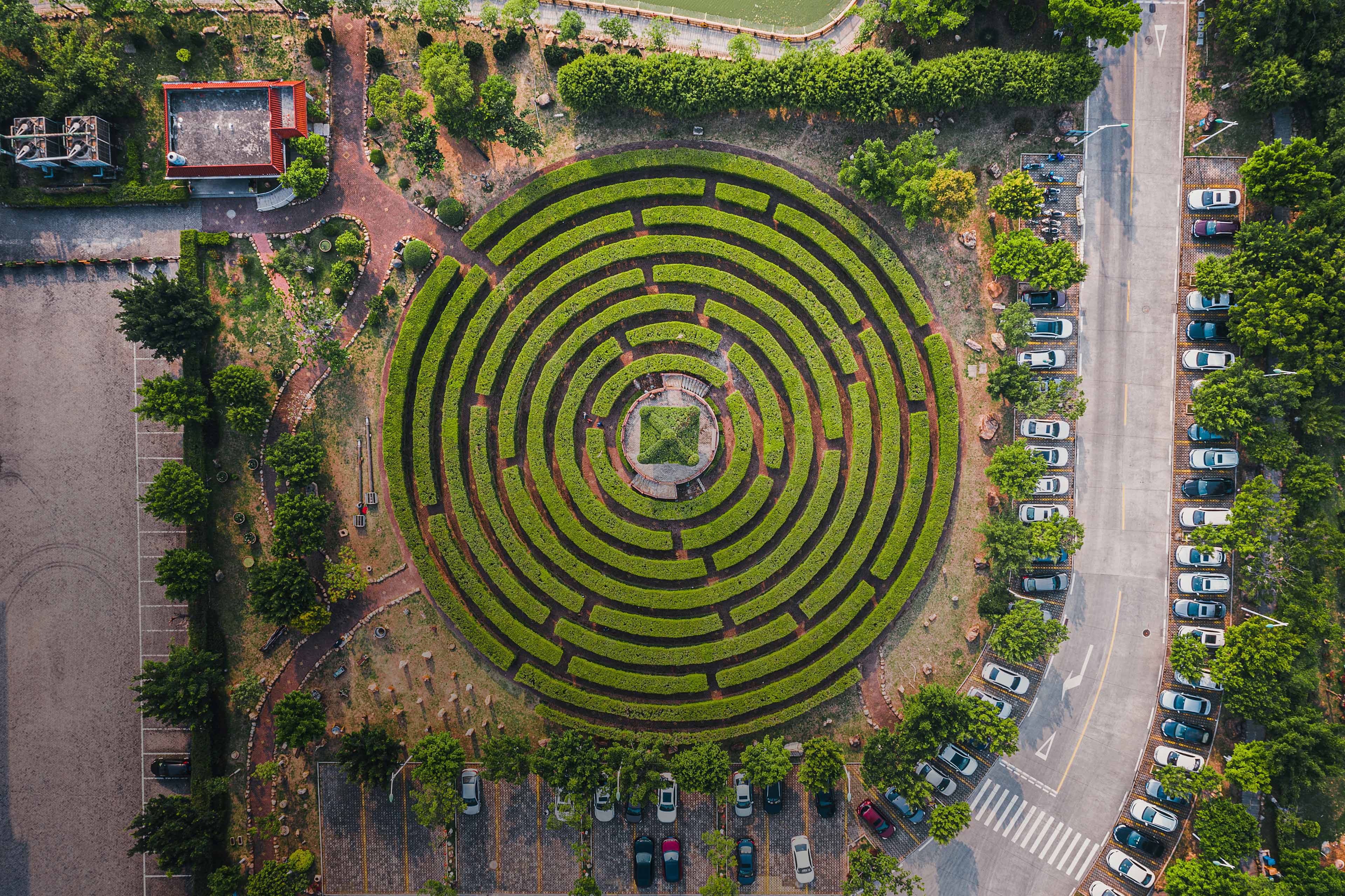 Aerial view of a circular garden maze and green pavilion