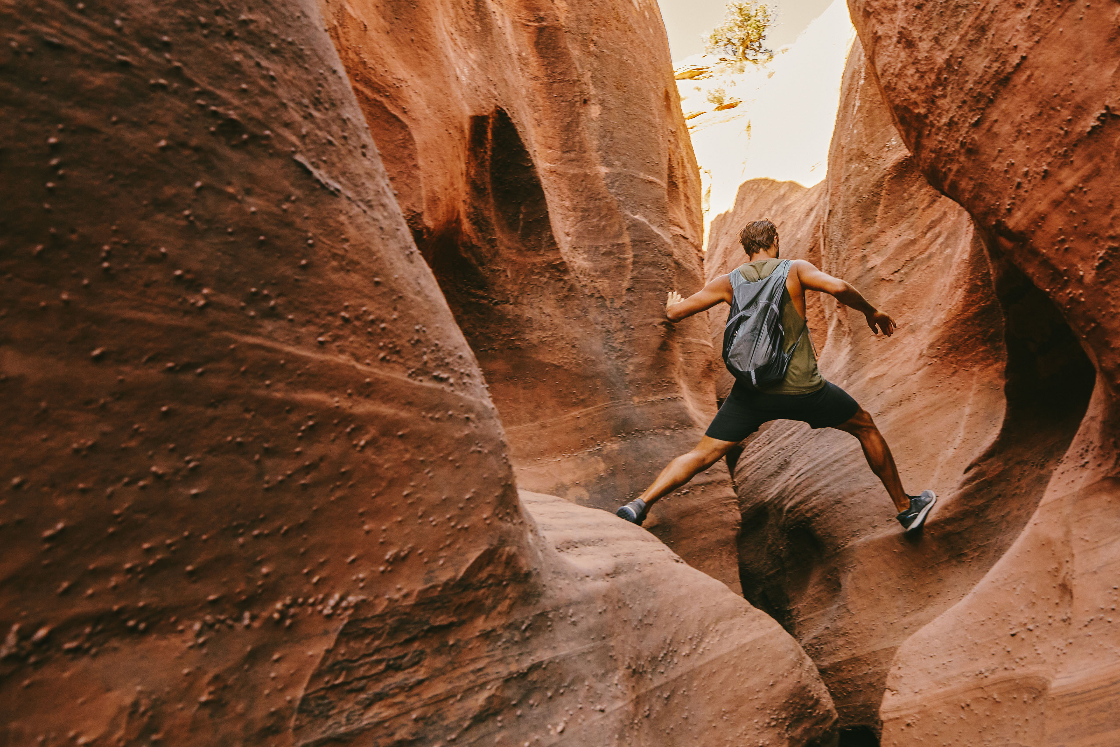 Back of a young man exploring slot canyons