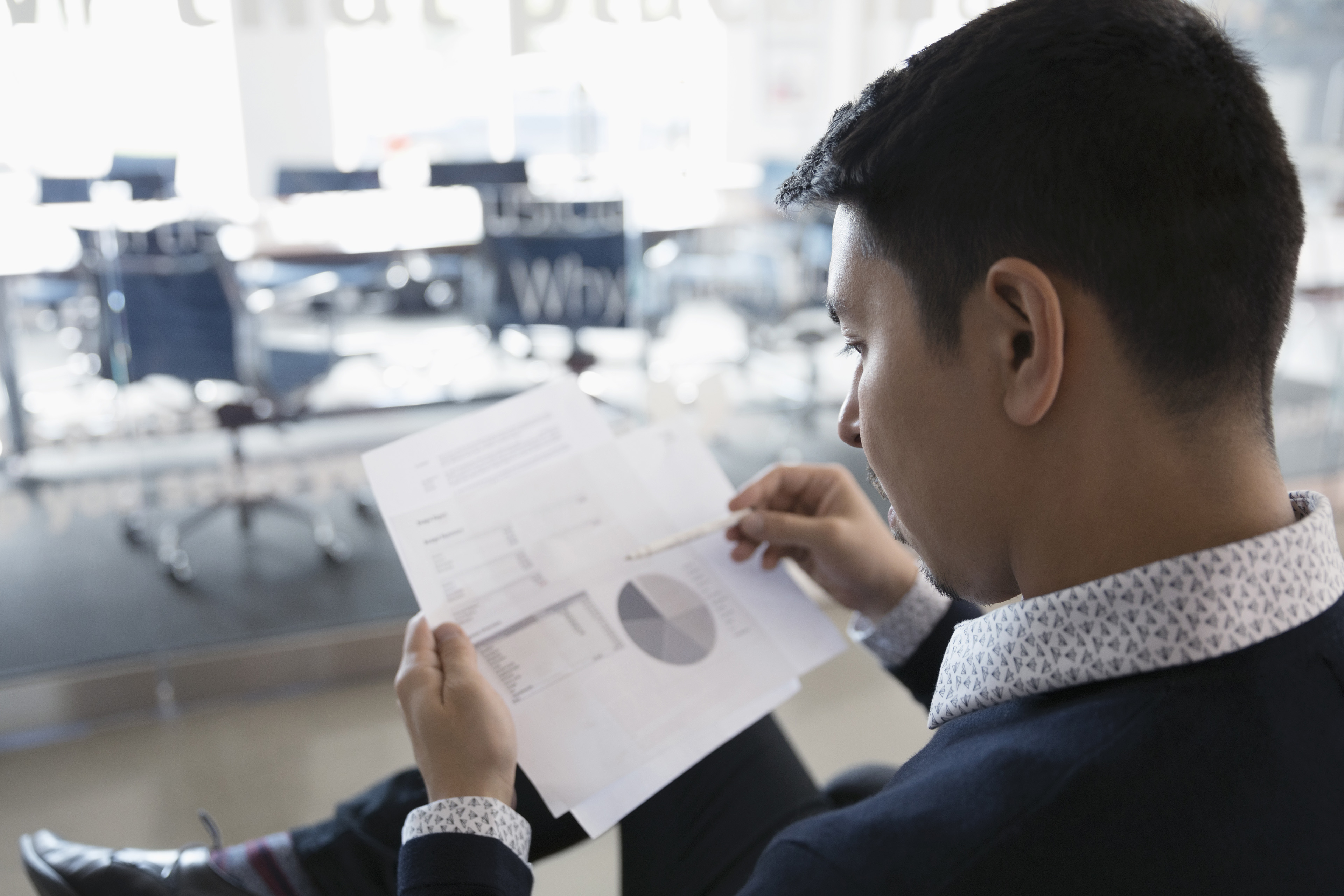 Businessman reviewing financial data paperwork office