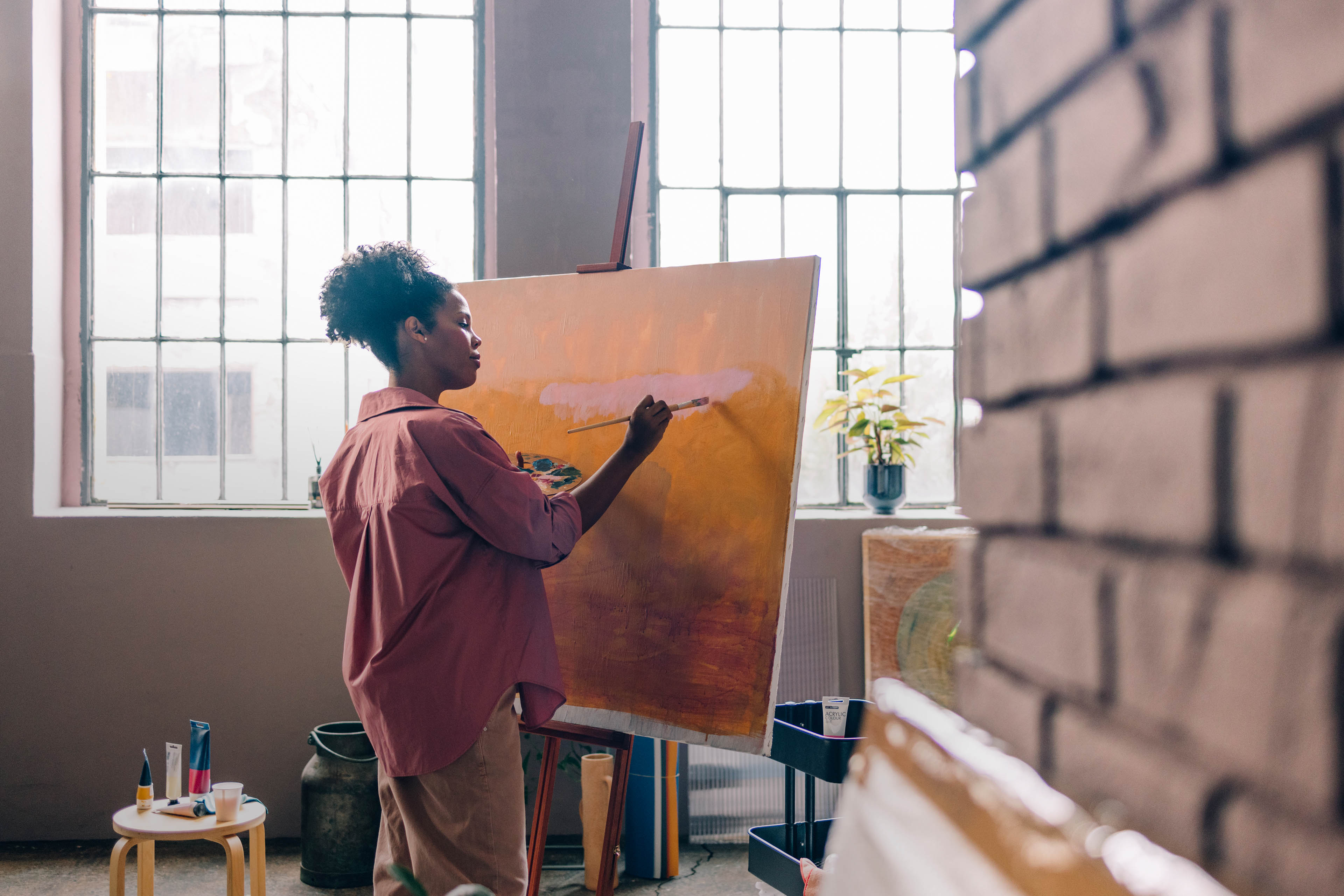 Female artist painting on canvas in her home studio