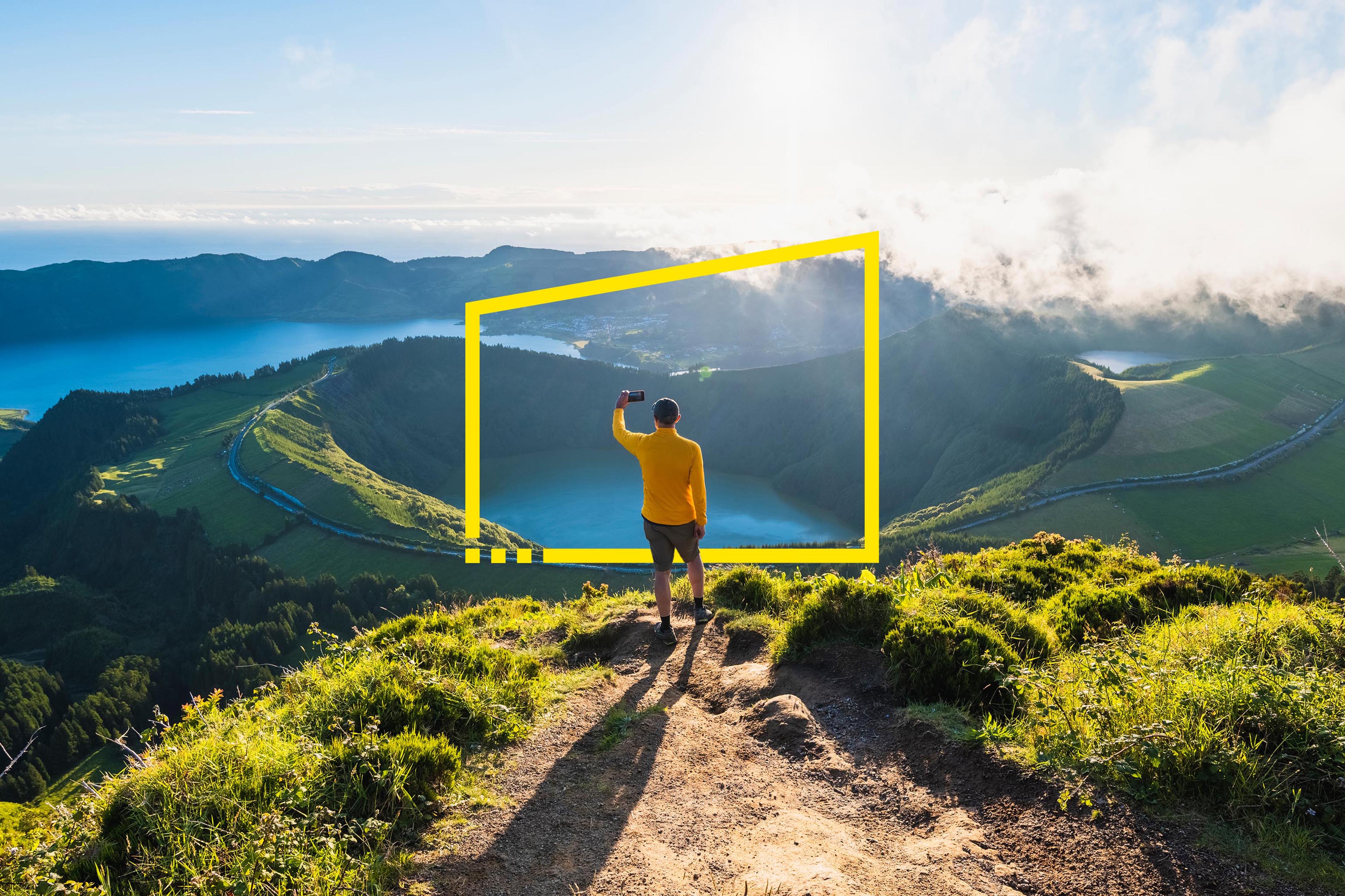 Man on top of a mountain photographing volcanoes in Sao Miguel, Azores