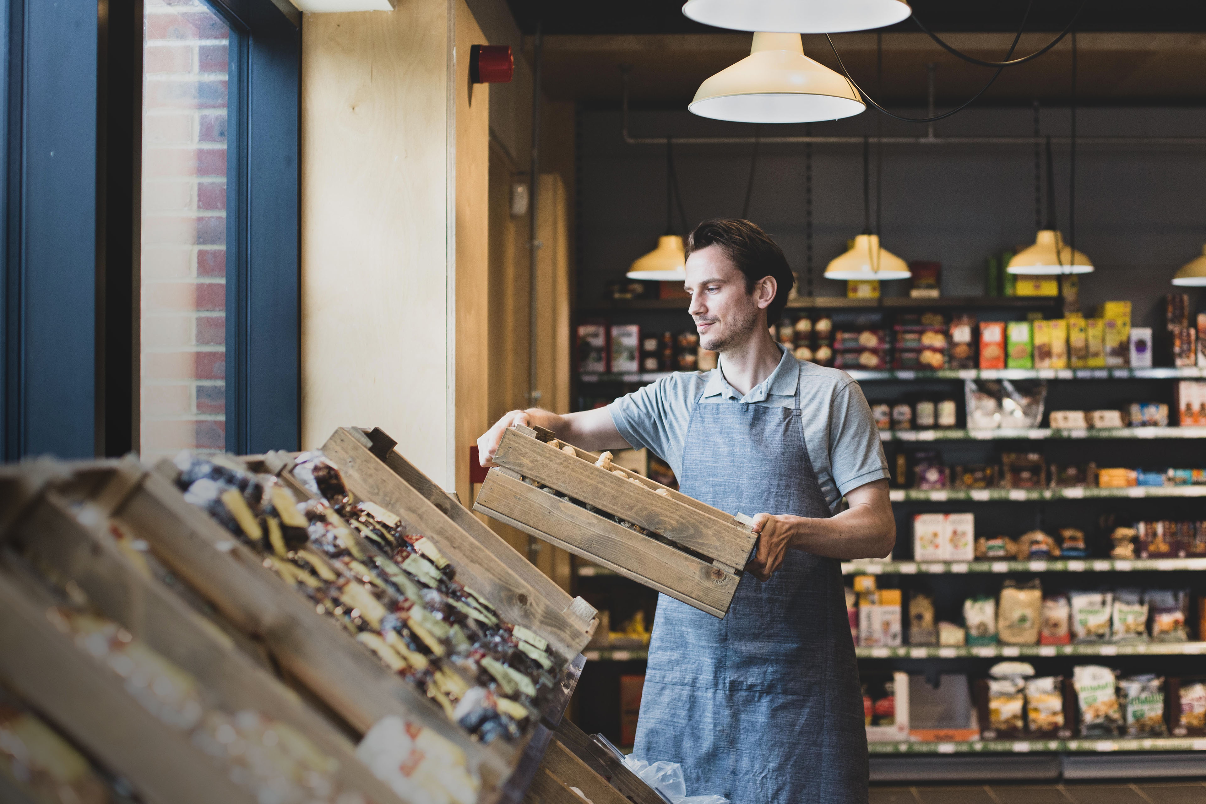 Small business owner of a food market stocking shelves