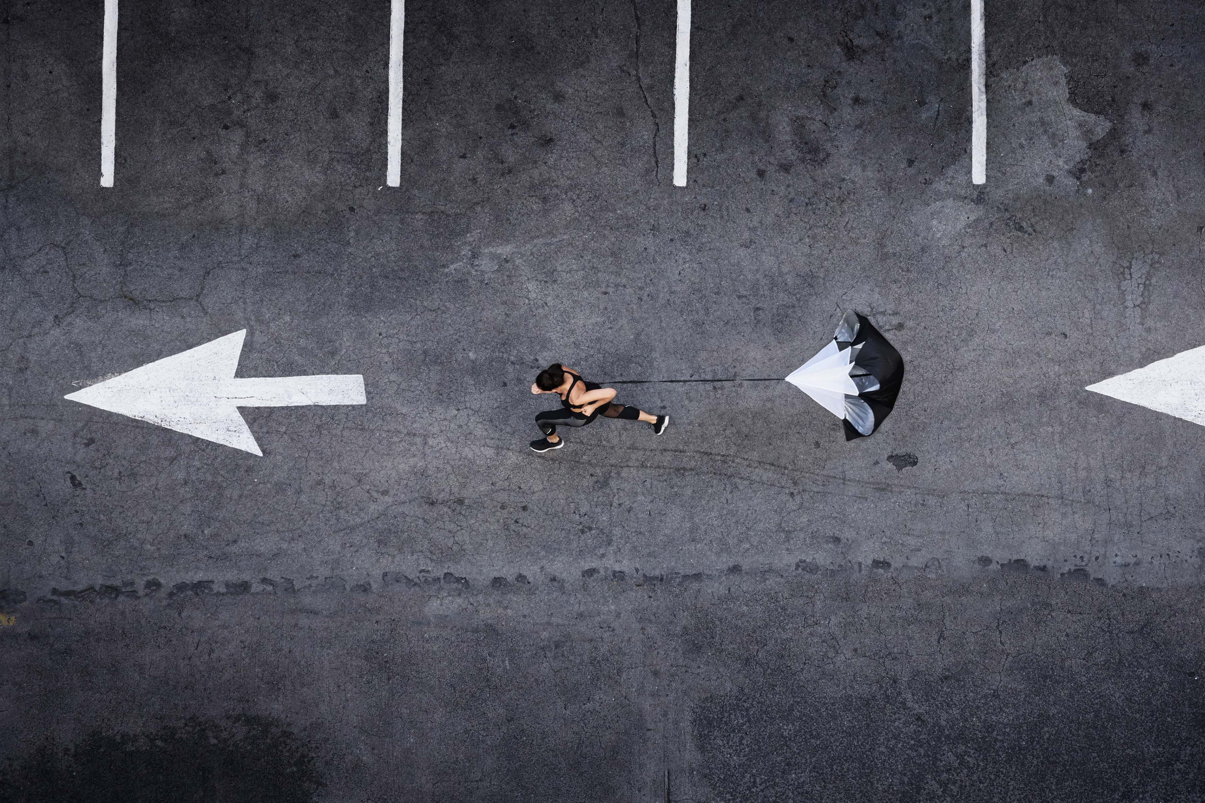 Woman running in drag parachute parking