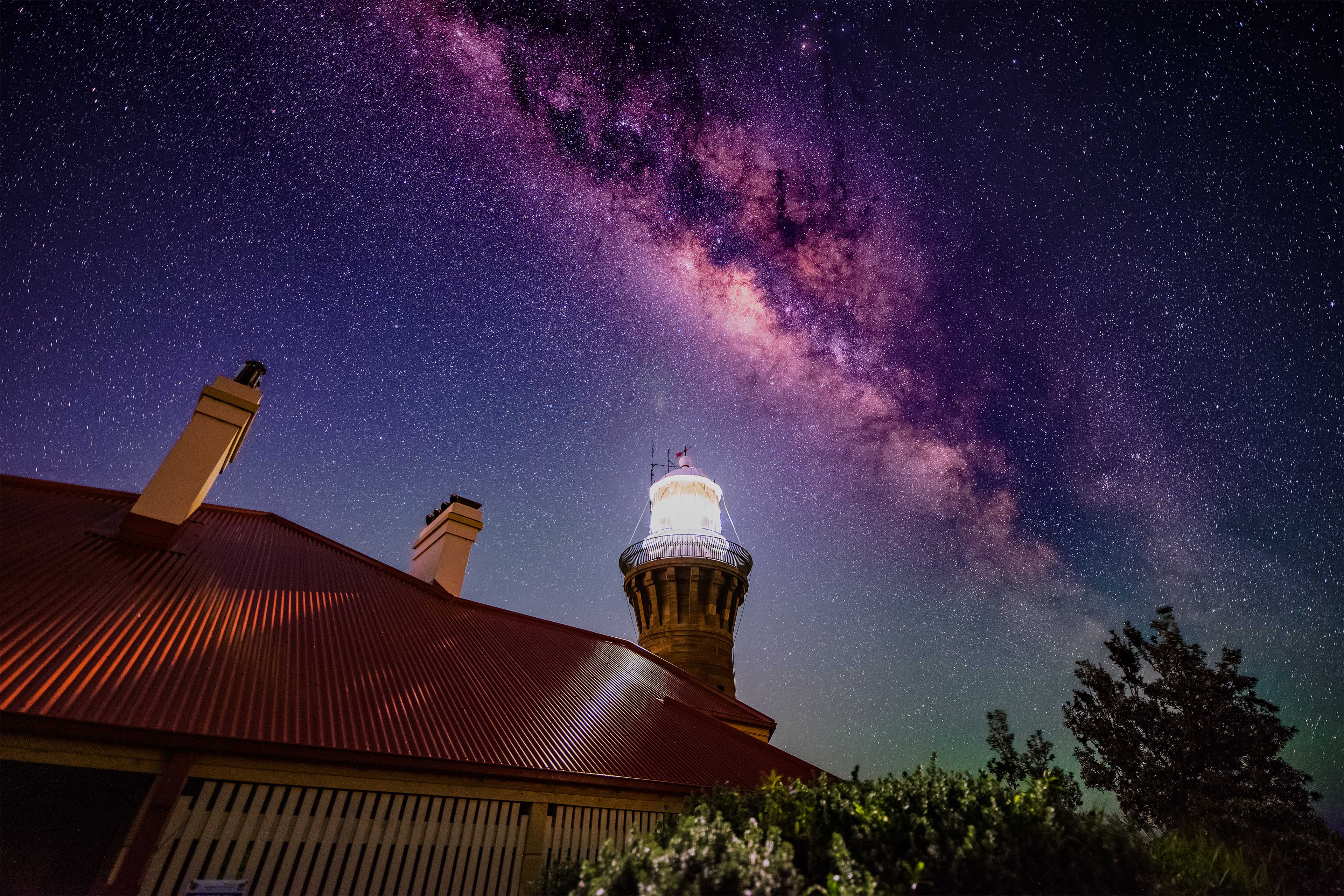 A lighthouse beacon under the night sky