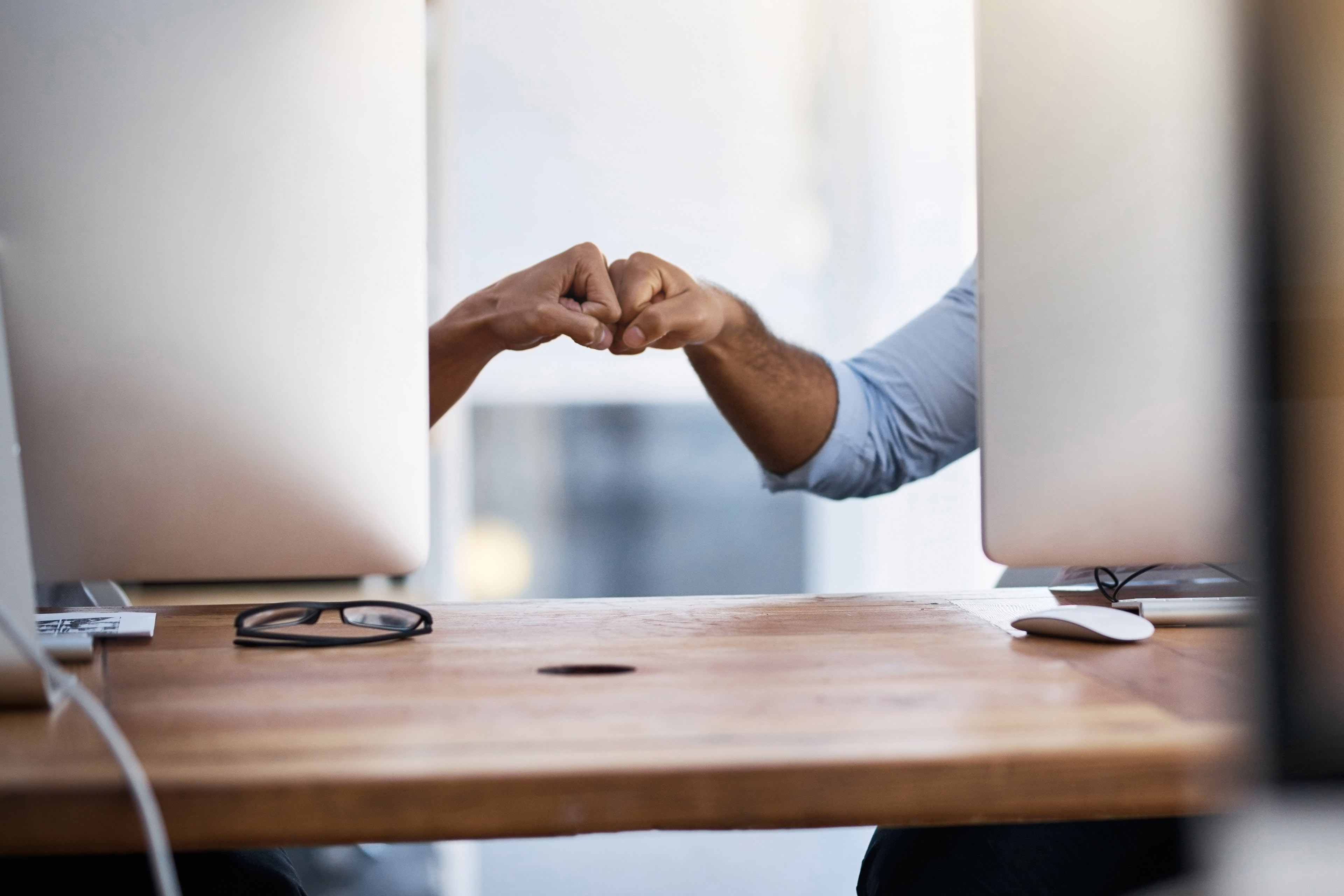 Businessmen fist bumping in an office