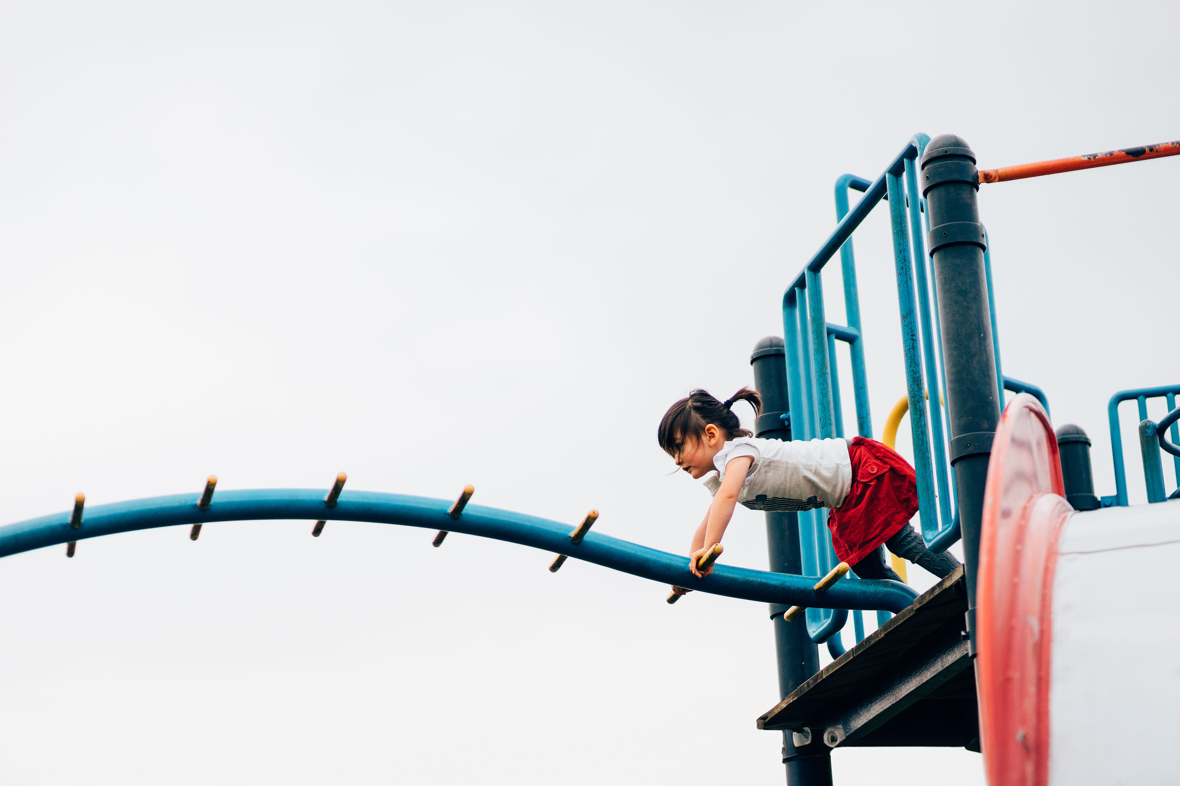 Little girl playing with playground equipment