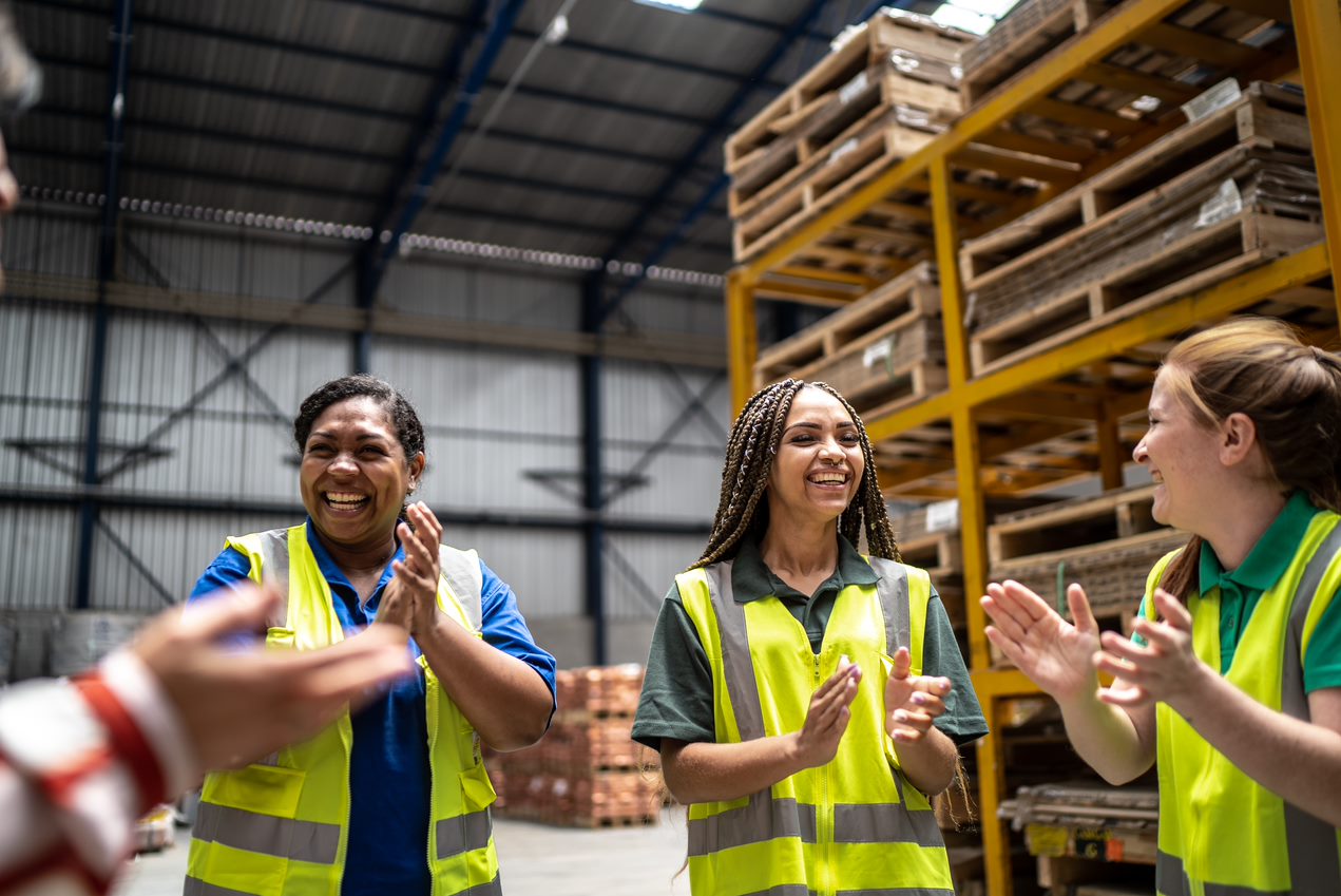 Employees applauding during meeting in a factory