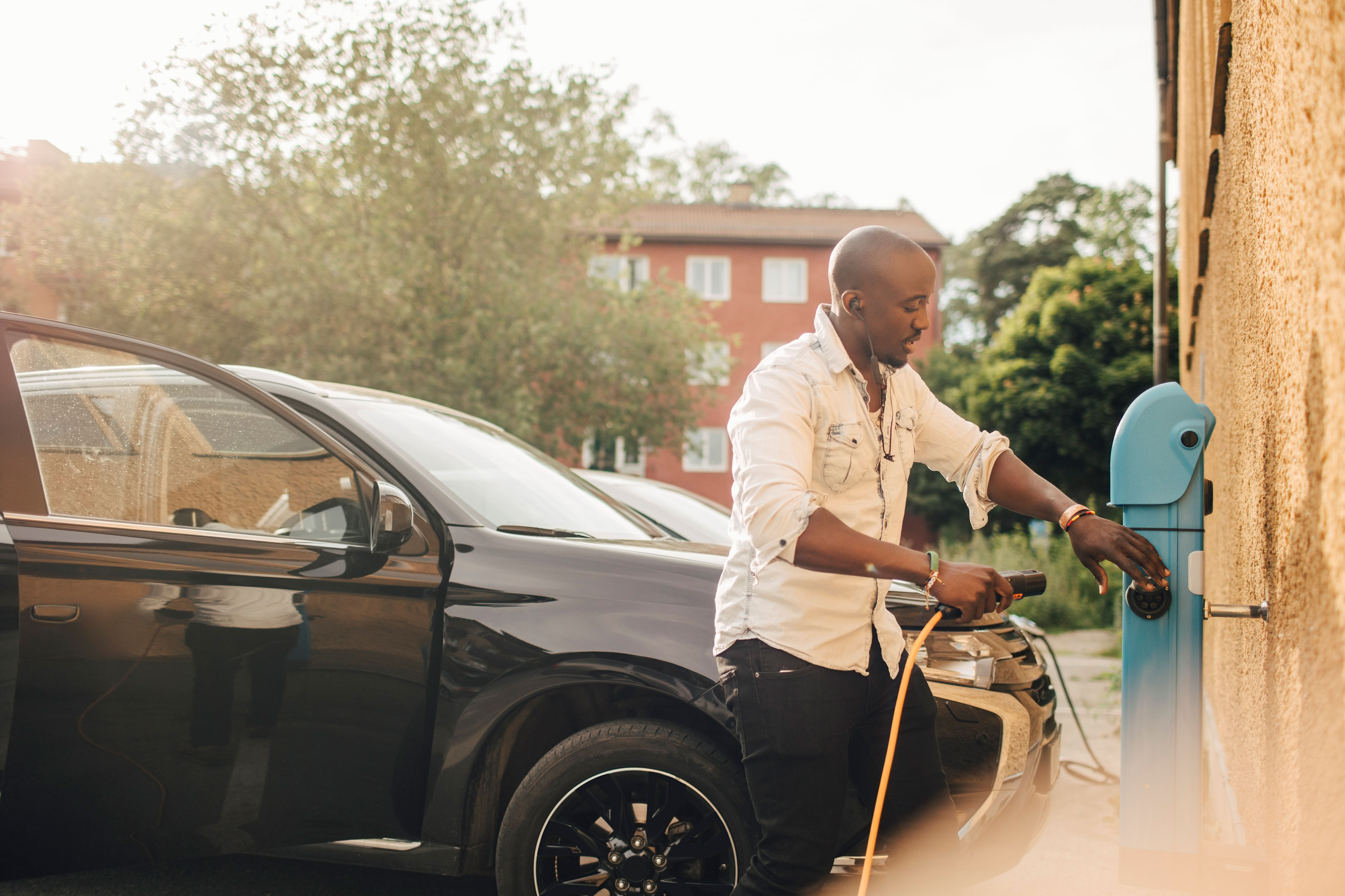 Man plugging in his electric car to charge