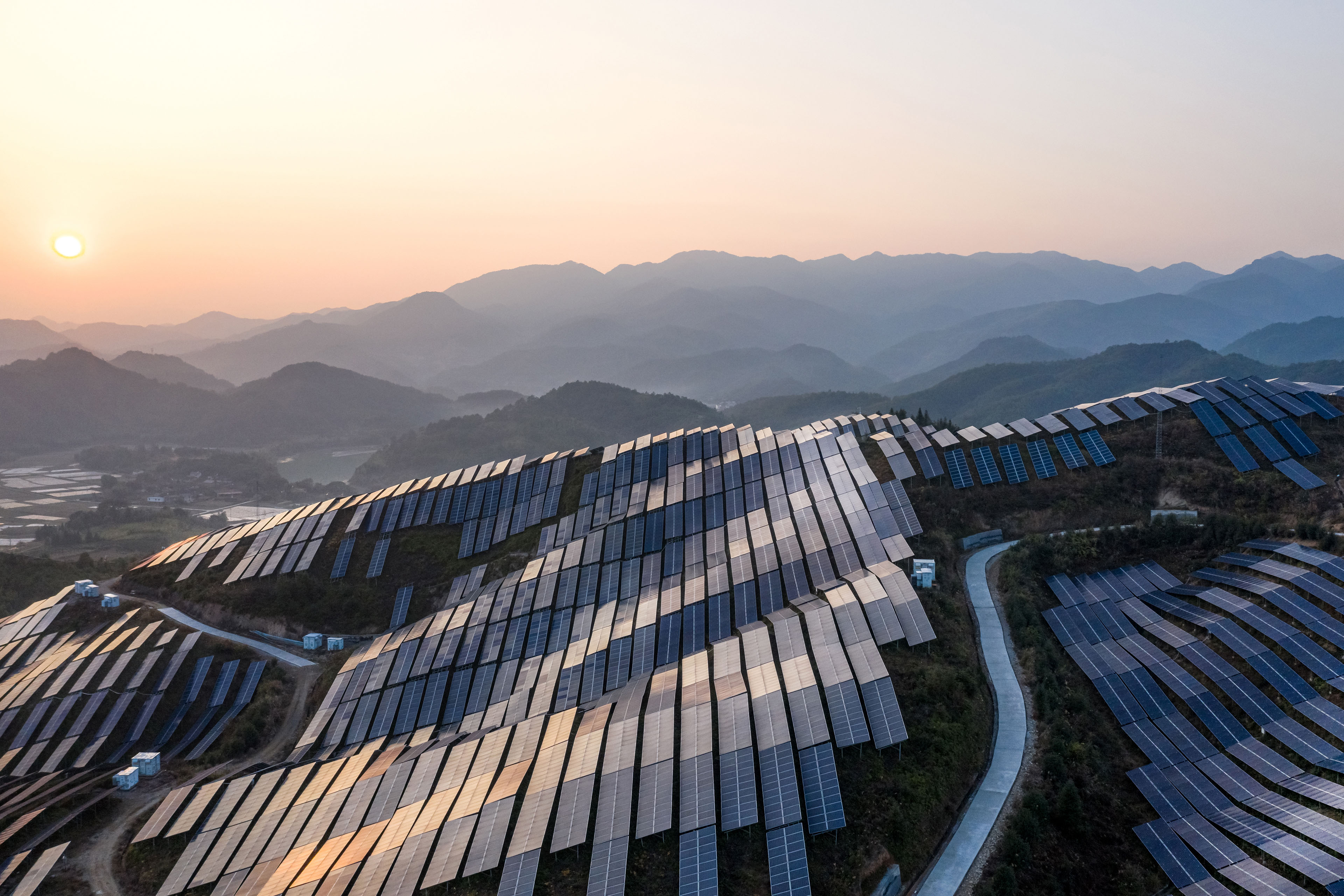 Planta de energía solar en la cima de la montaña al atardecer