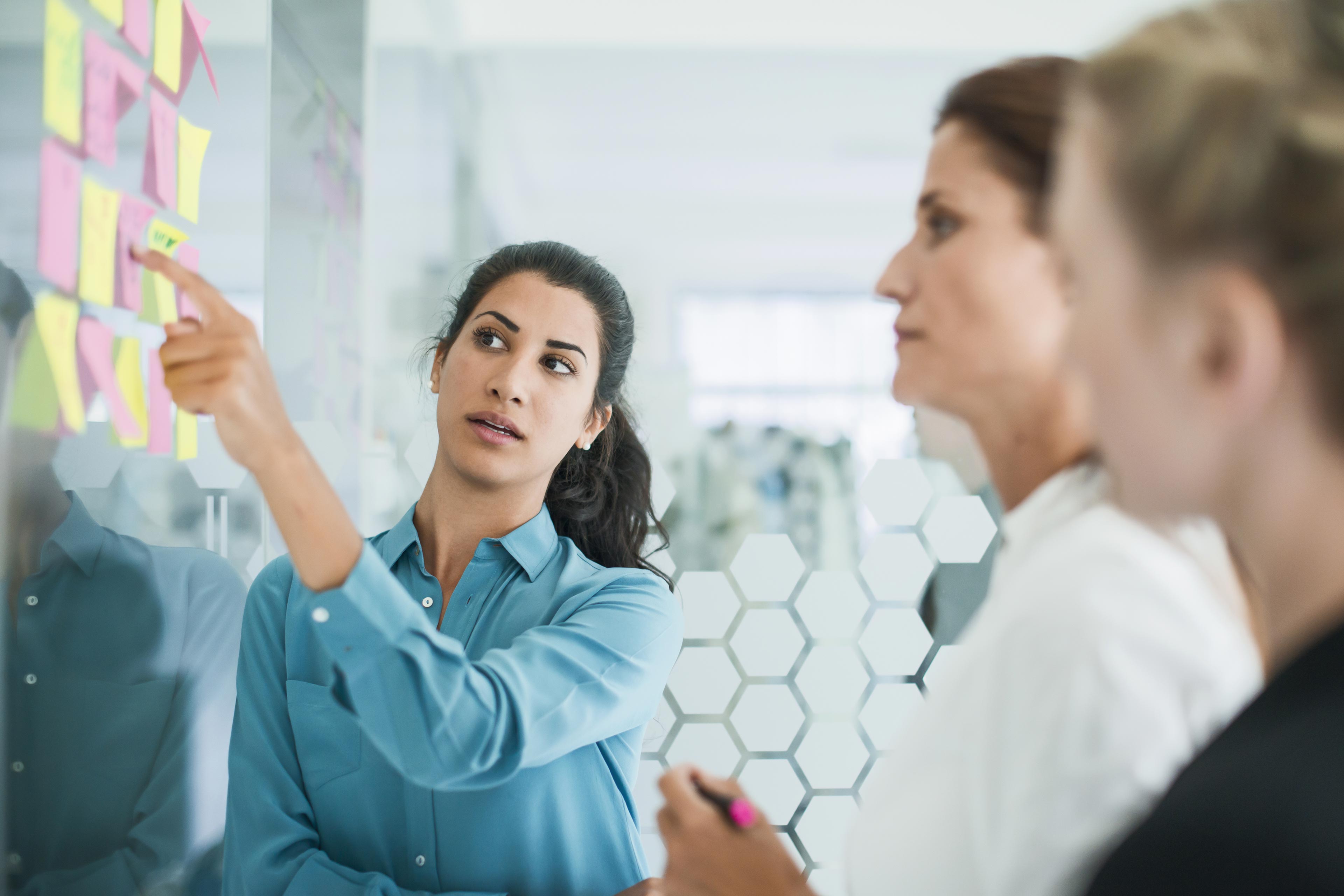 Three women brainstorming in meeting 