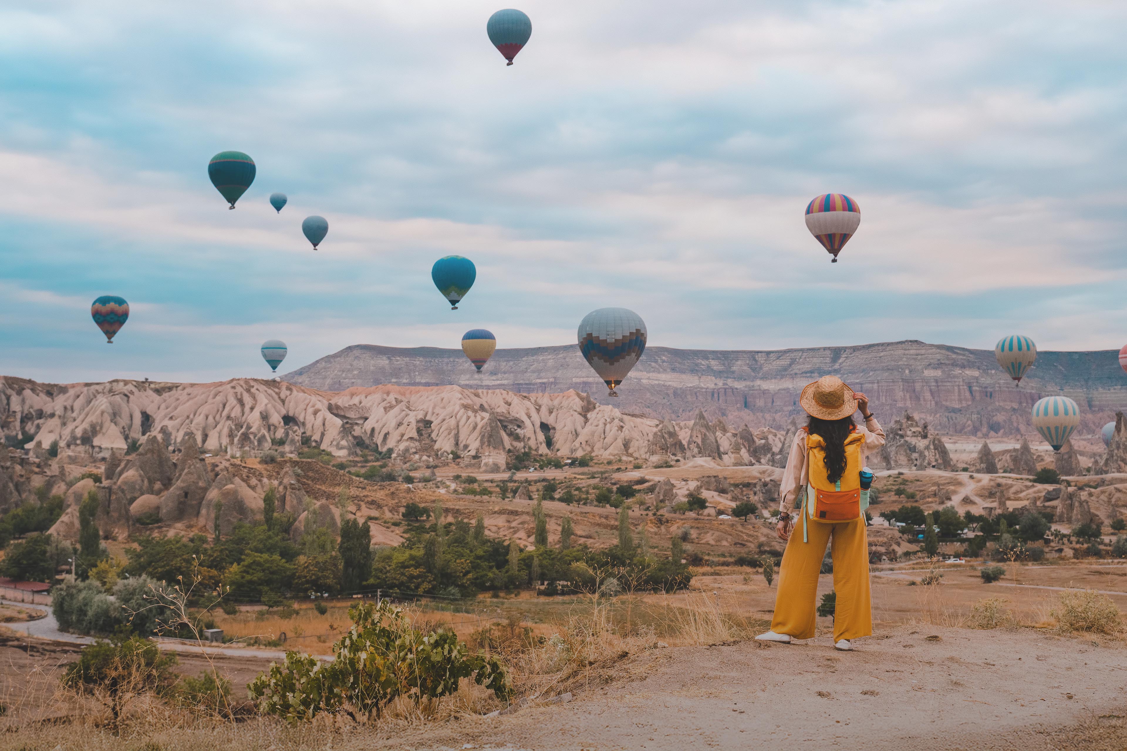 Traveler backpacker girl watching hot air balloons