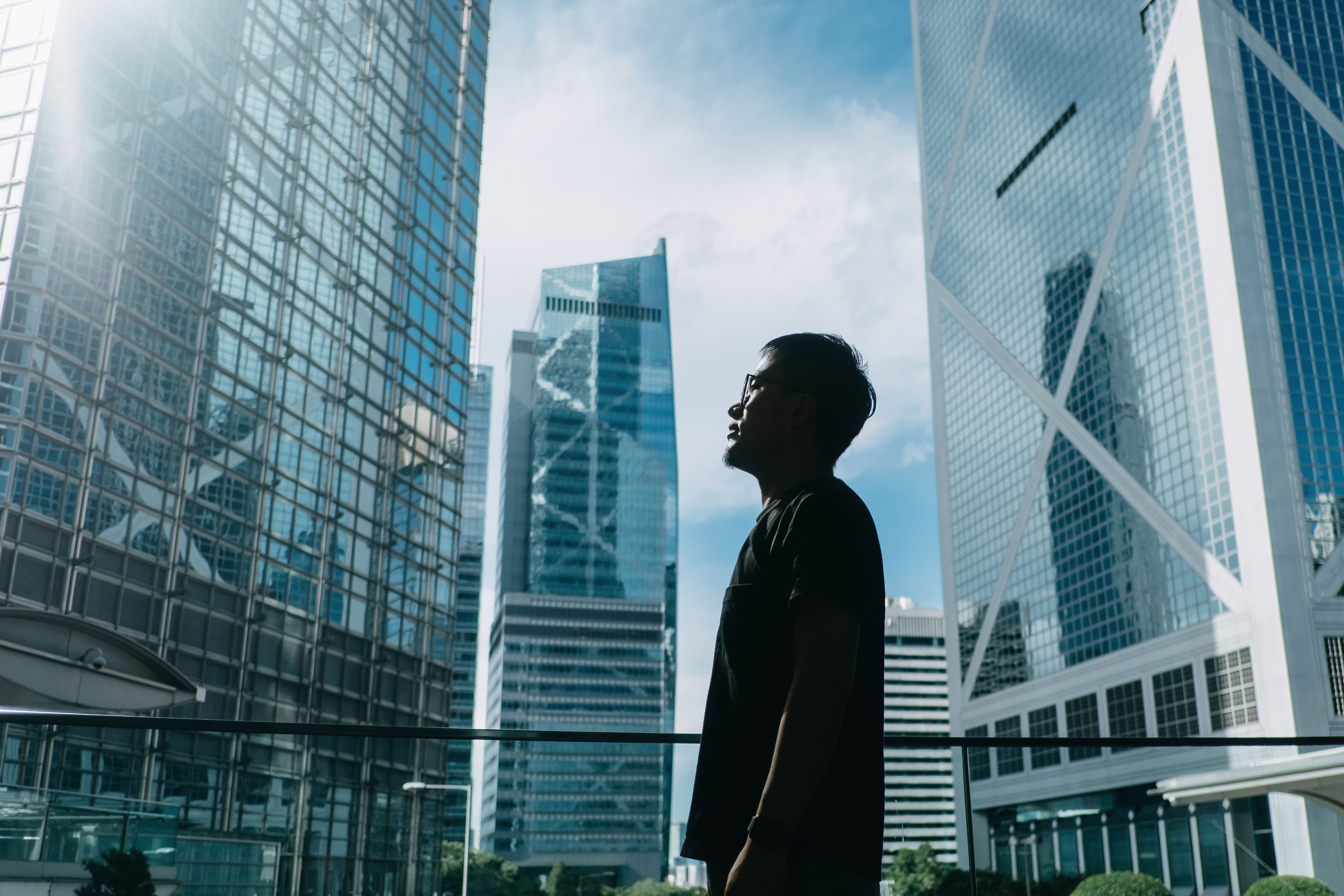 Professional young businessman standing against financial district skyscrapers