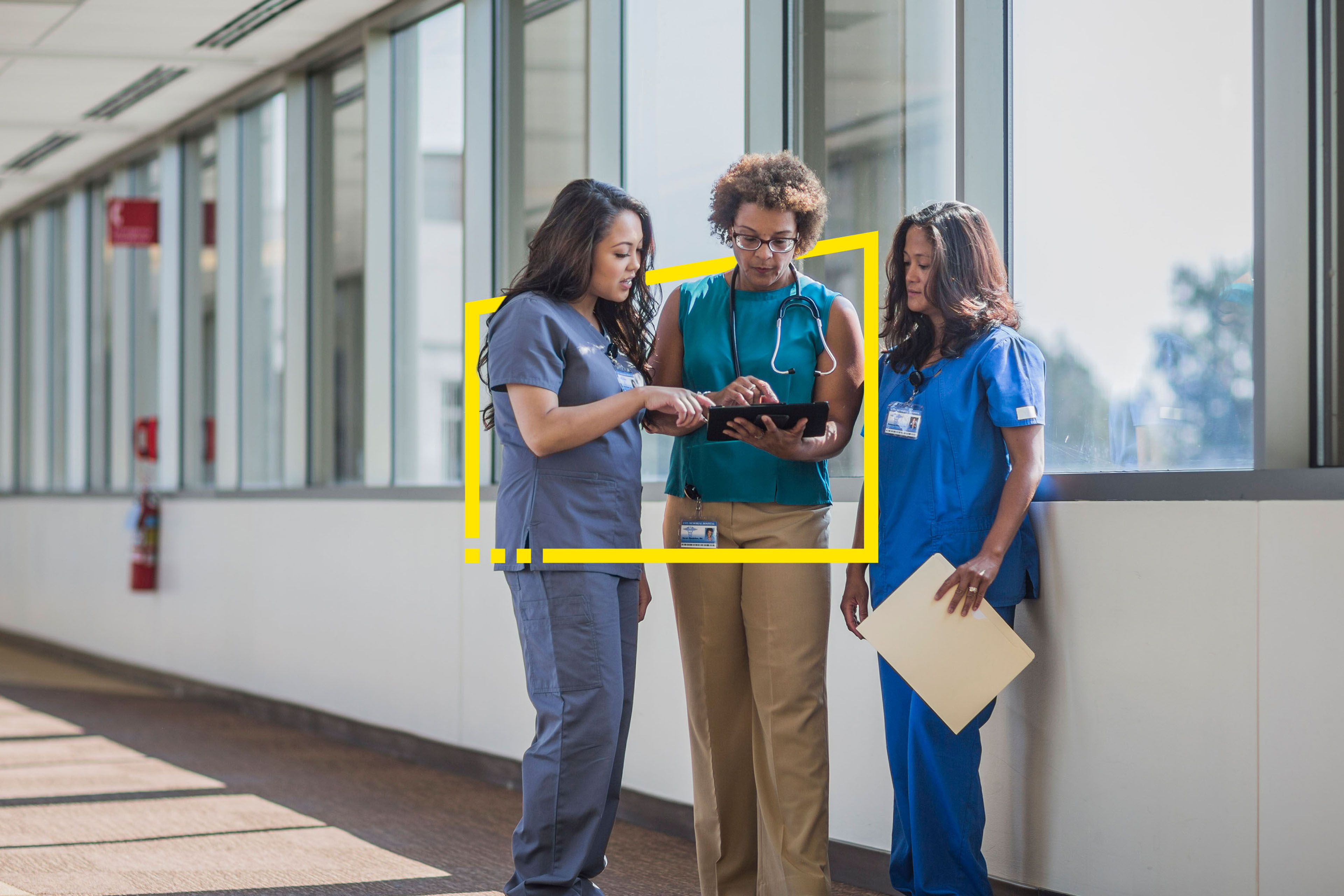 Nurses speak with doctor looking at digital tablet