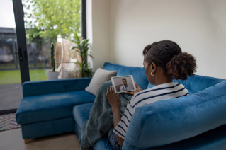 Sick African woman staying at home and talking to her doctor through mobile