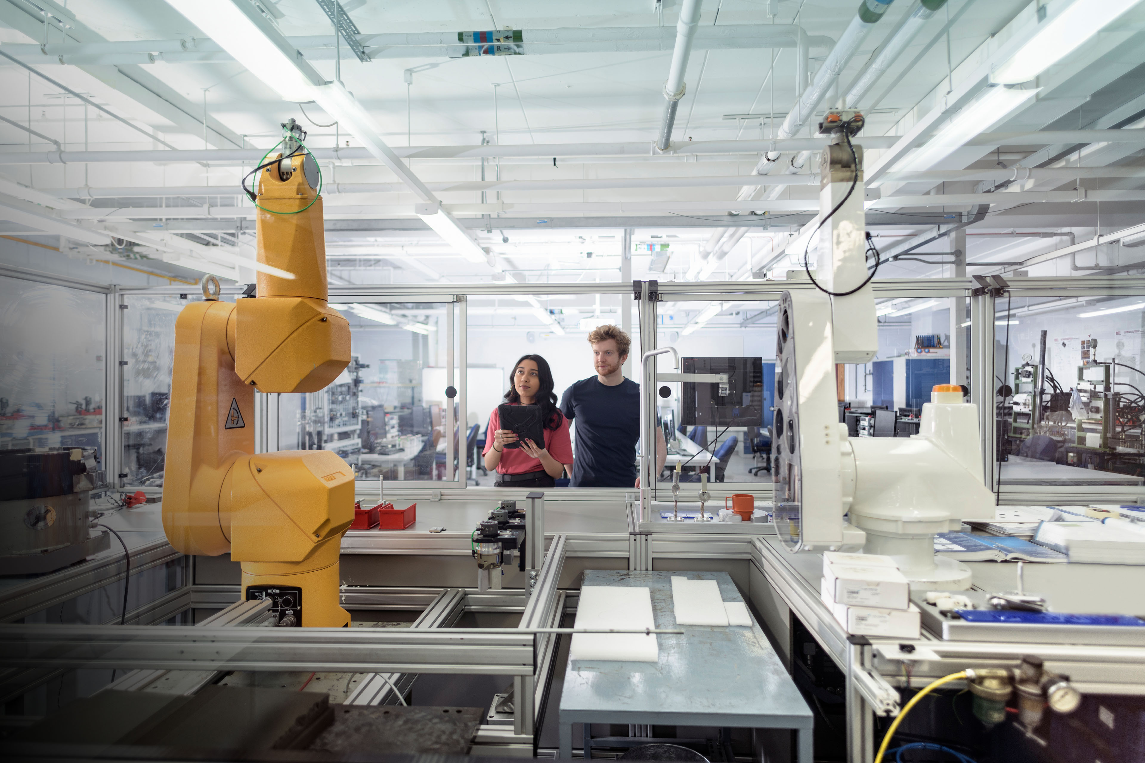 Male and female trainee engineers with robotic equipment