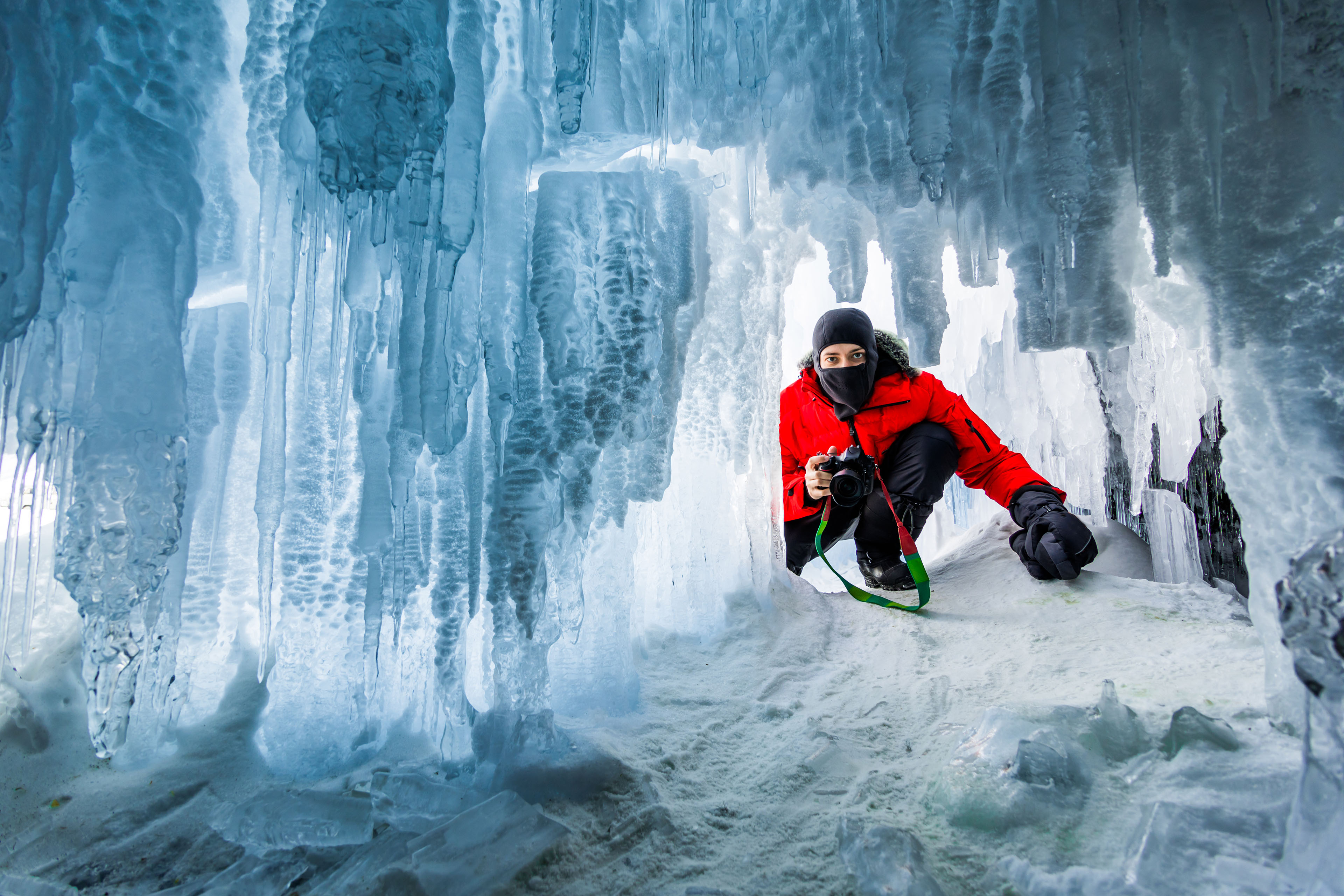 Photographer in the ice cave sunset lake Baikal Russia