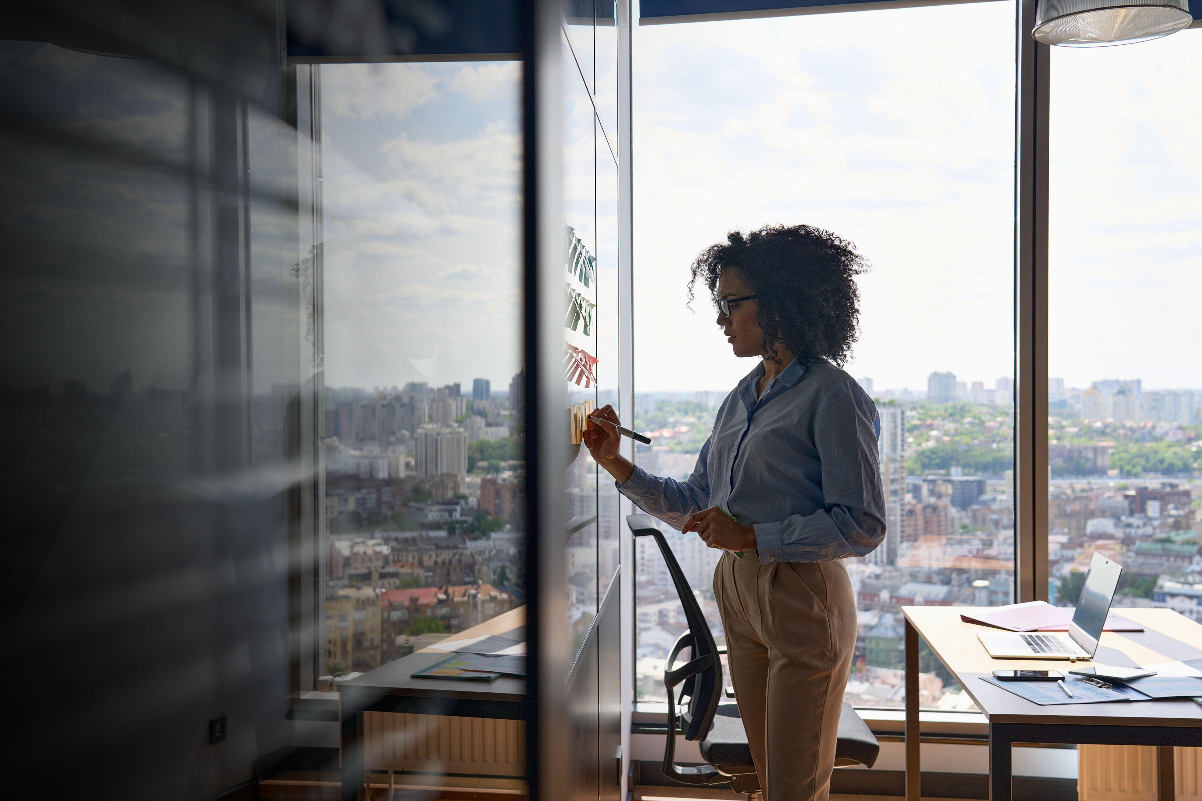 ey-african-american-ceo-writing-on-sticky-notes-in-office-whiteboard