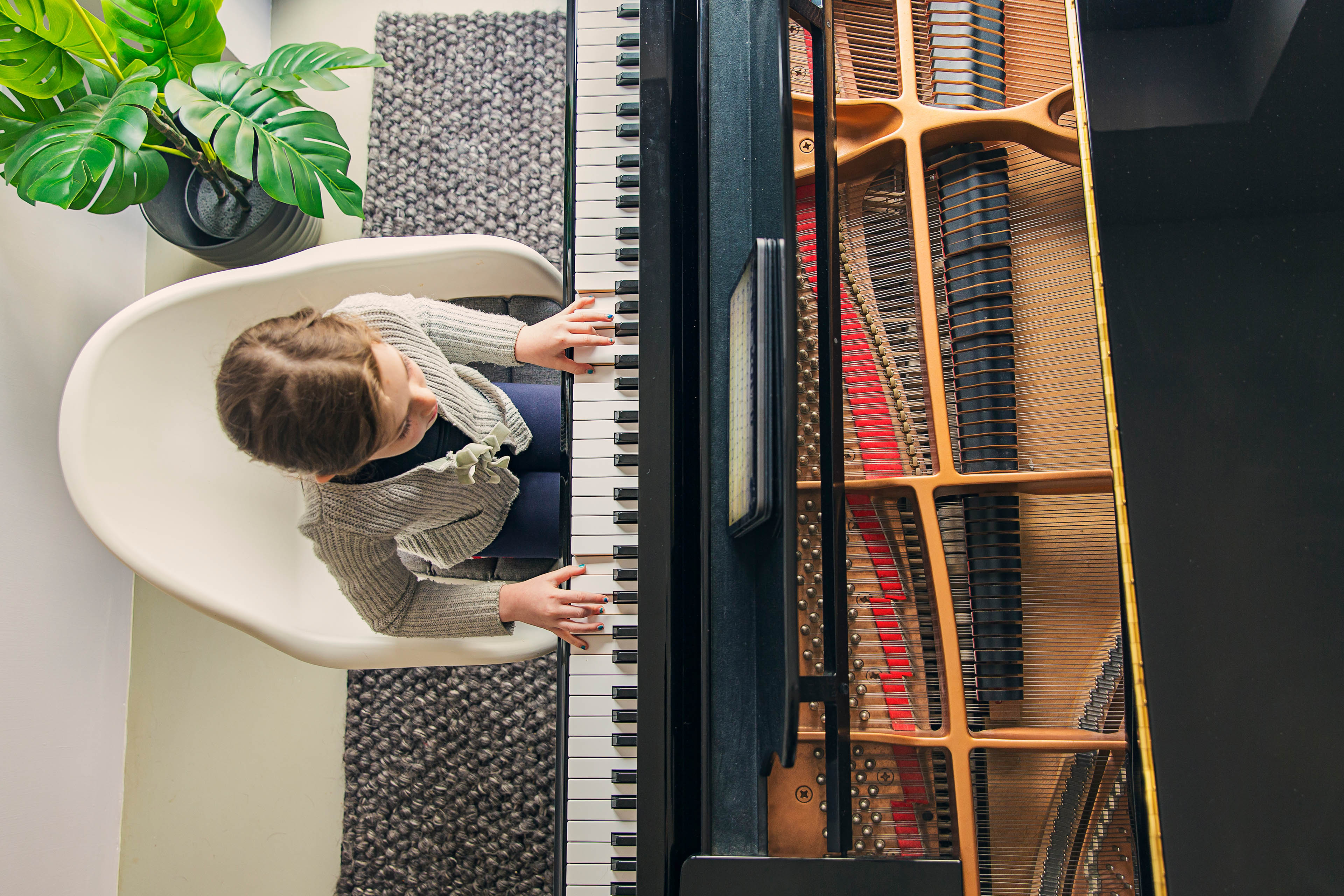 Young girl playing grand piano