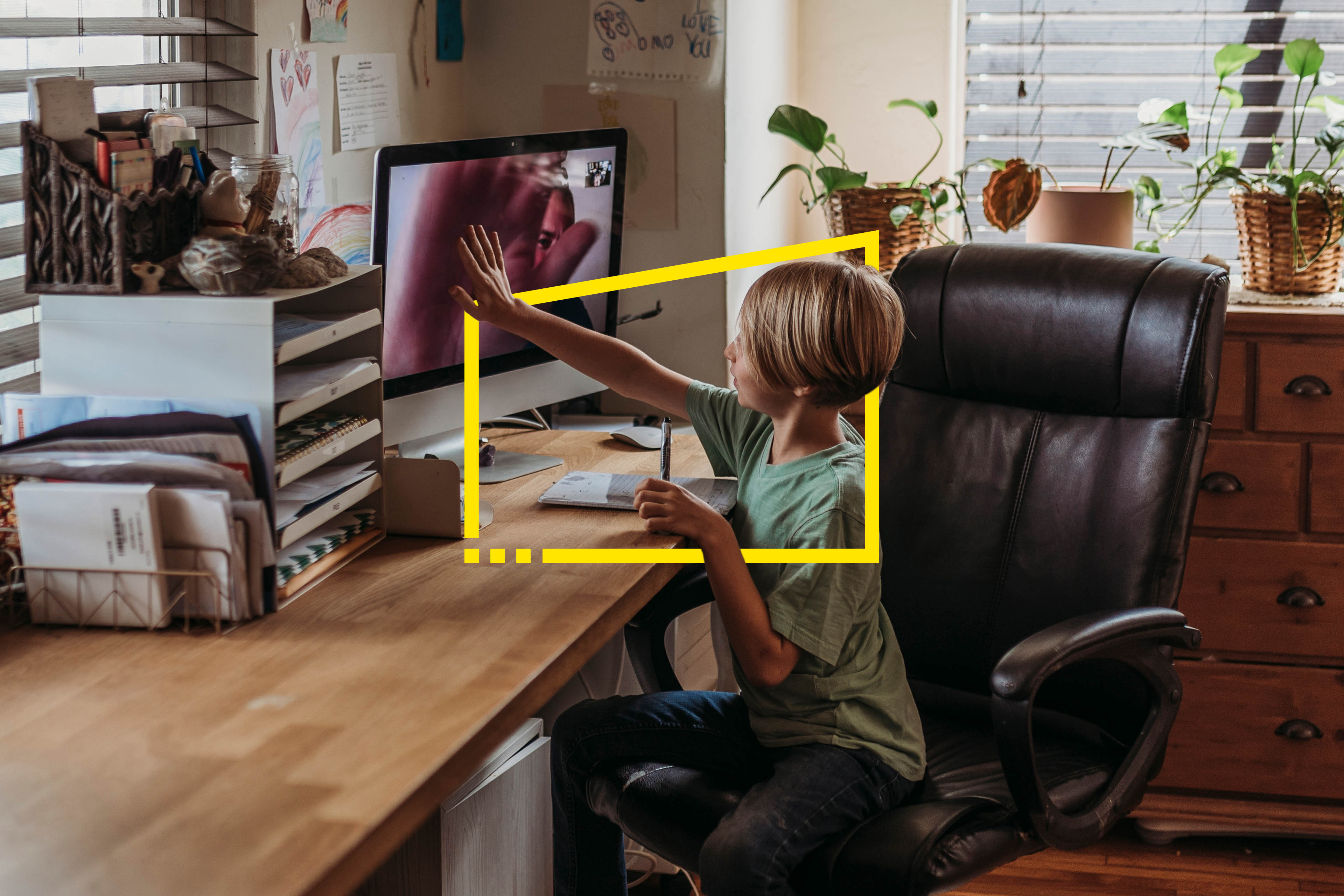 Wide view of young student getting virtual high five from teacher during online class