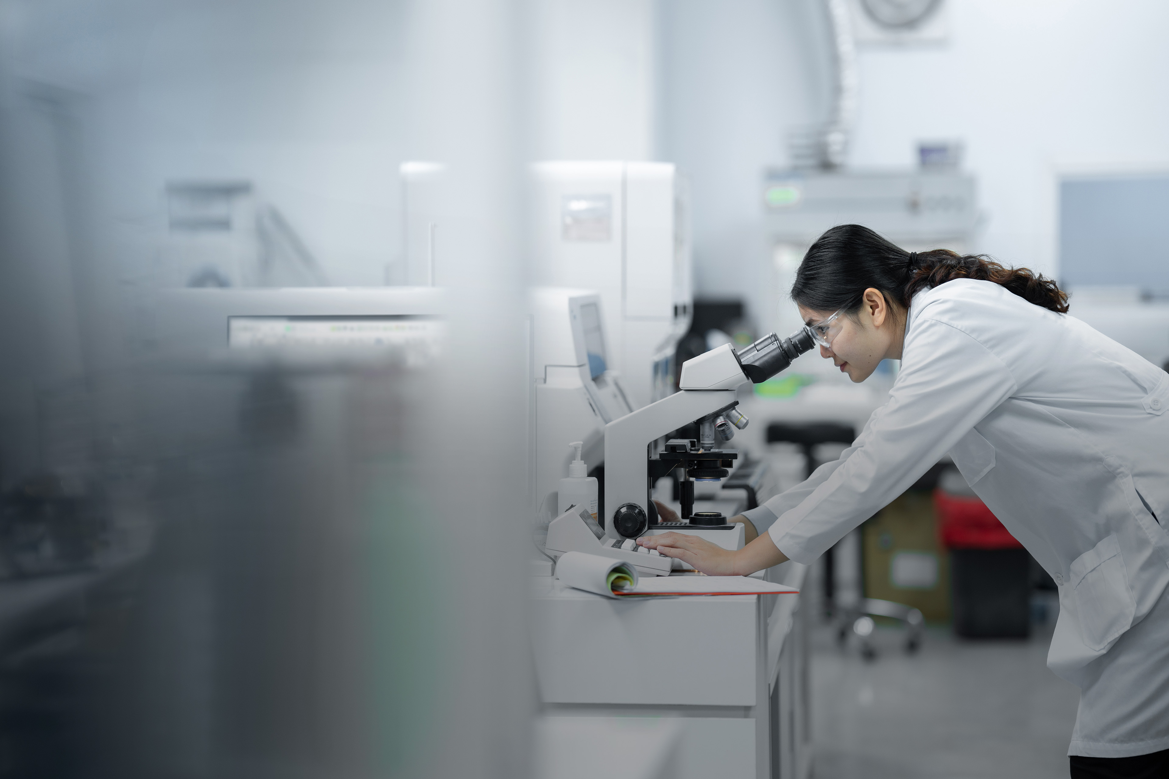 Medical technician doctor looking at the microscope