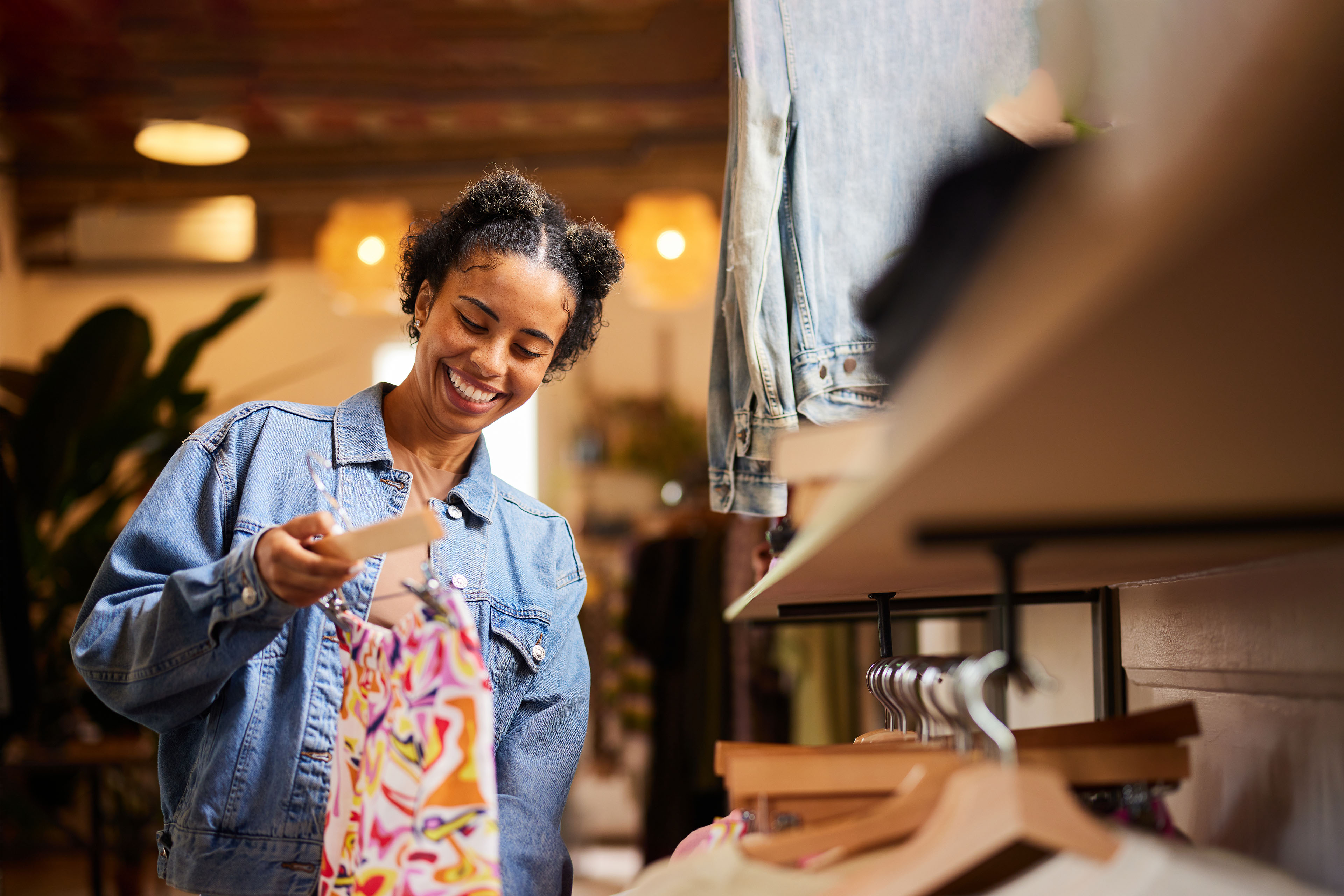 Smiling young woman shopping for clothes in a trendy boutique