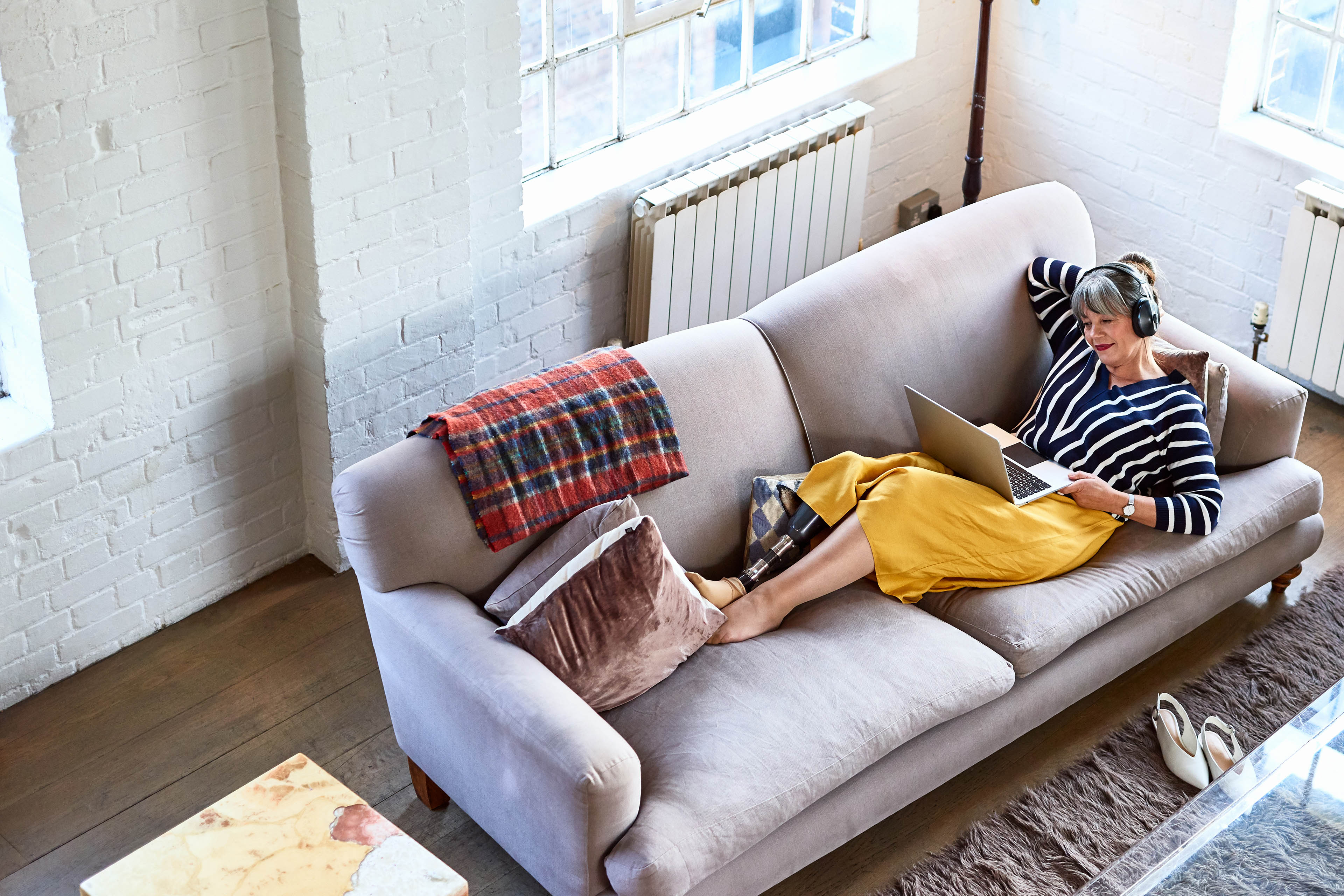 High angle view of woman on sofa with laptop