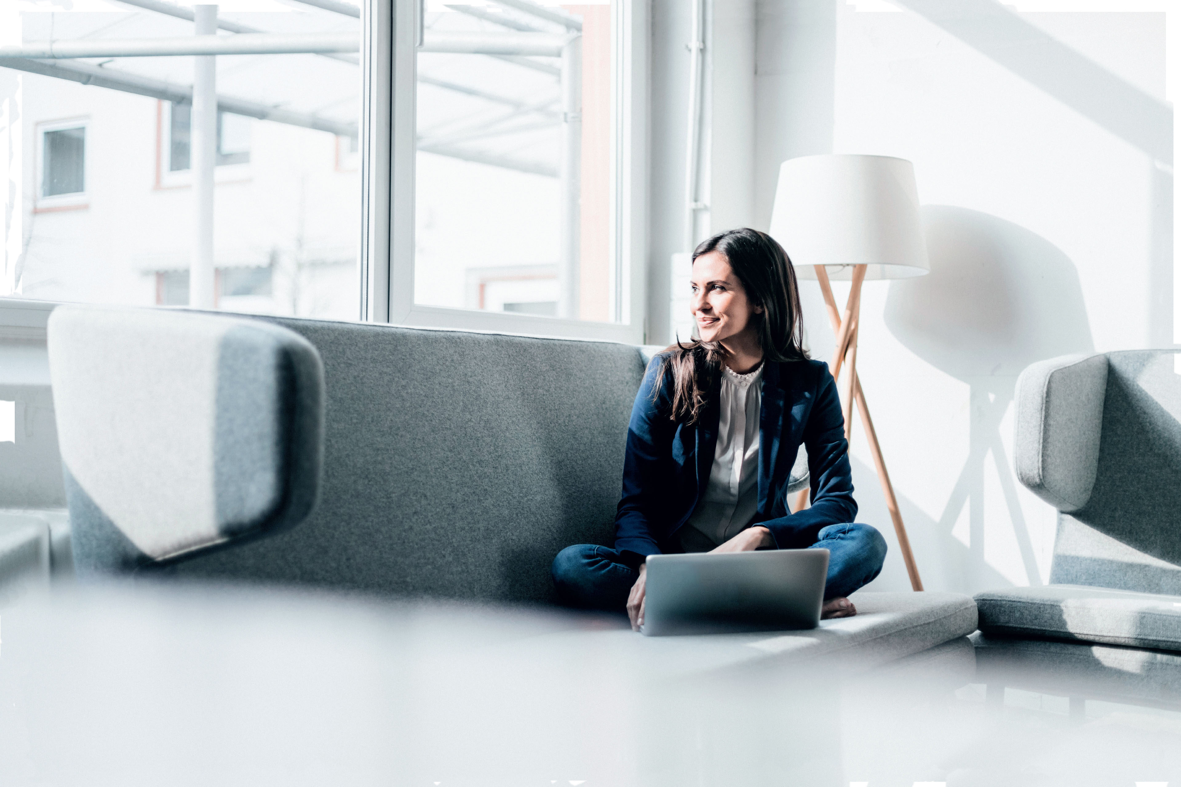 Smiling woman using laptop on couch