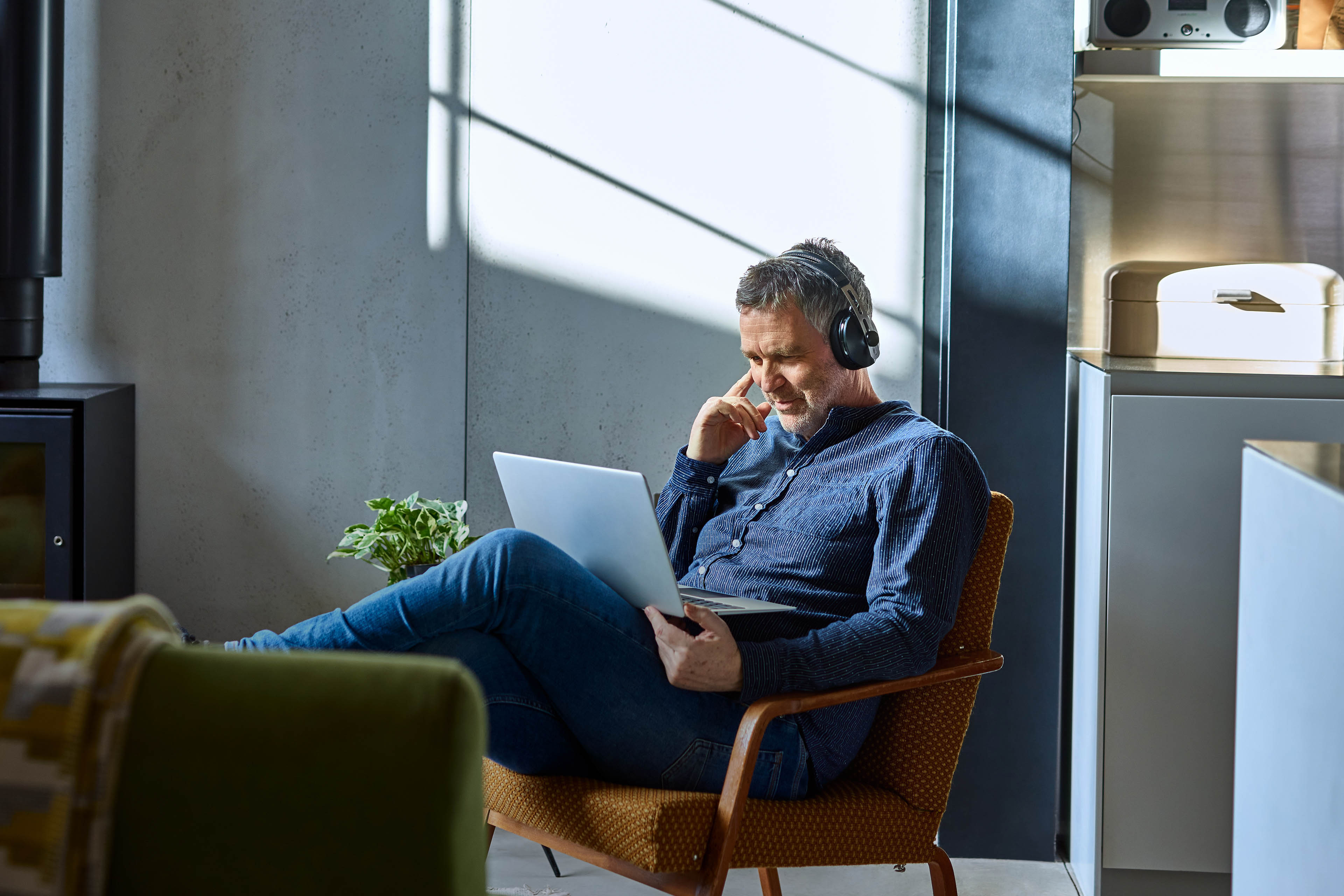 Mature man listening to music on laptop