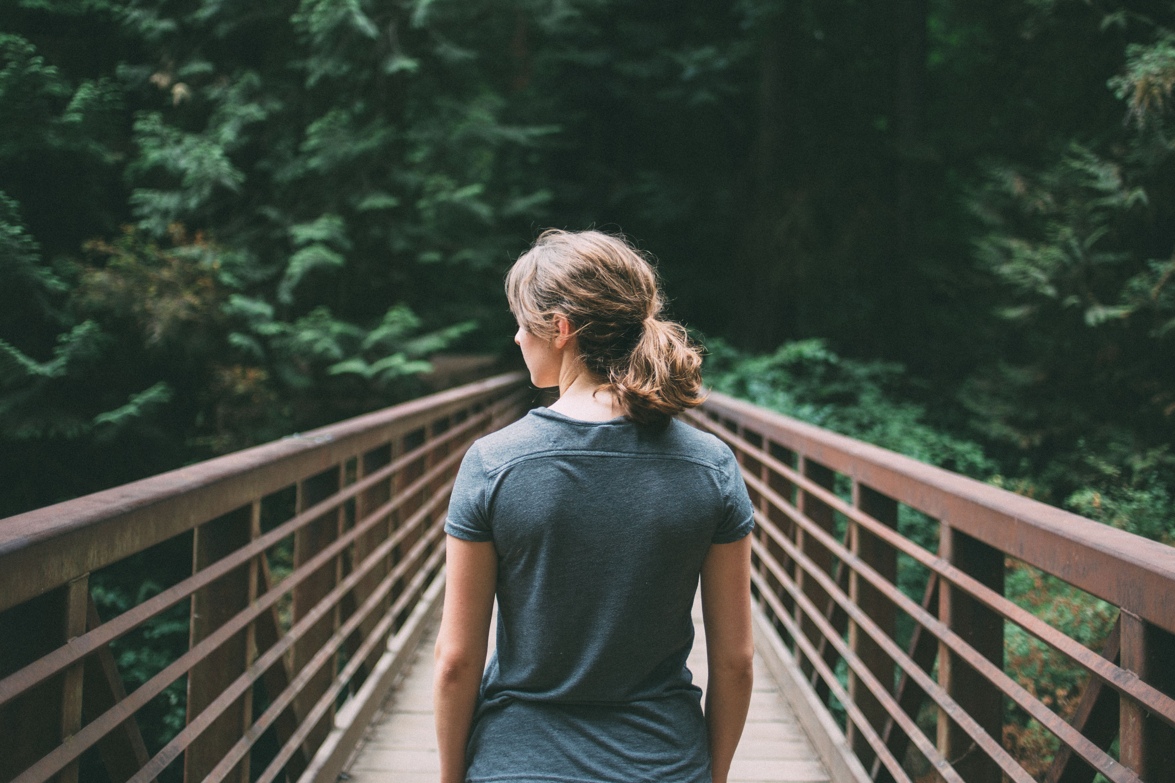 A rearview of woman walking on a footbridge