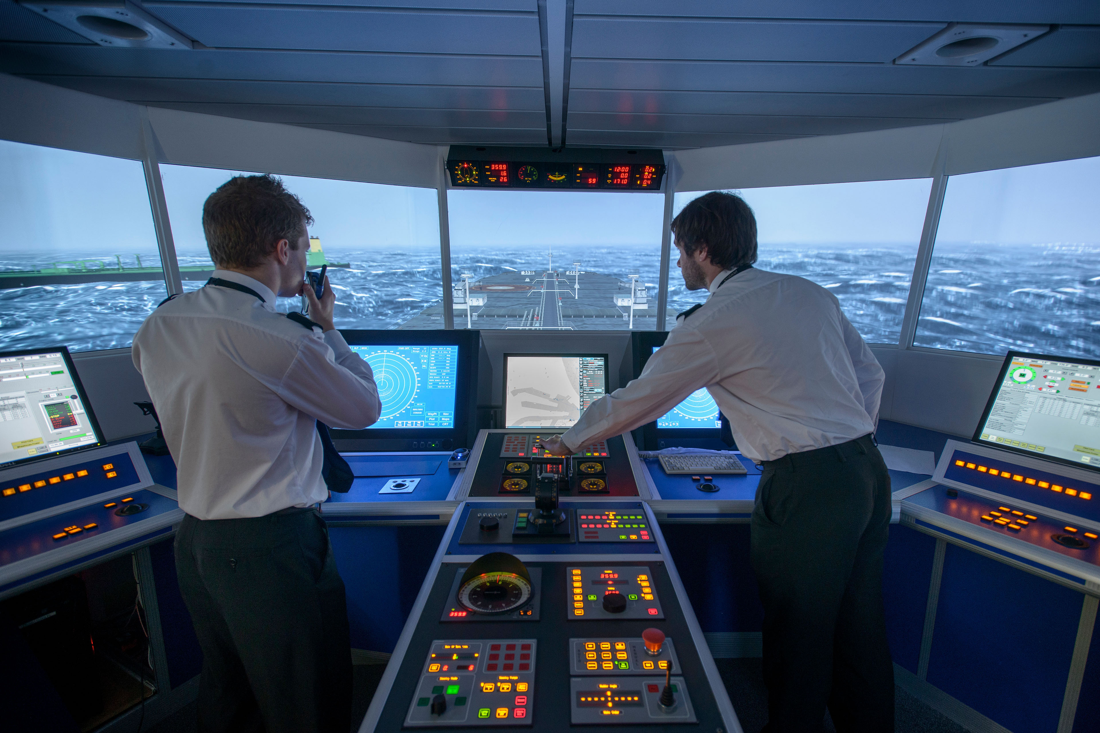  Students operating equipment in ship's bridge simulation room