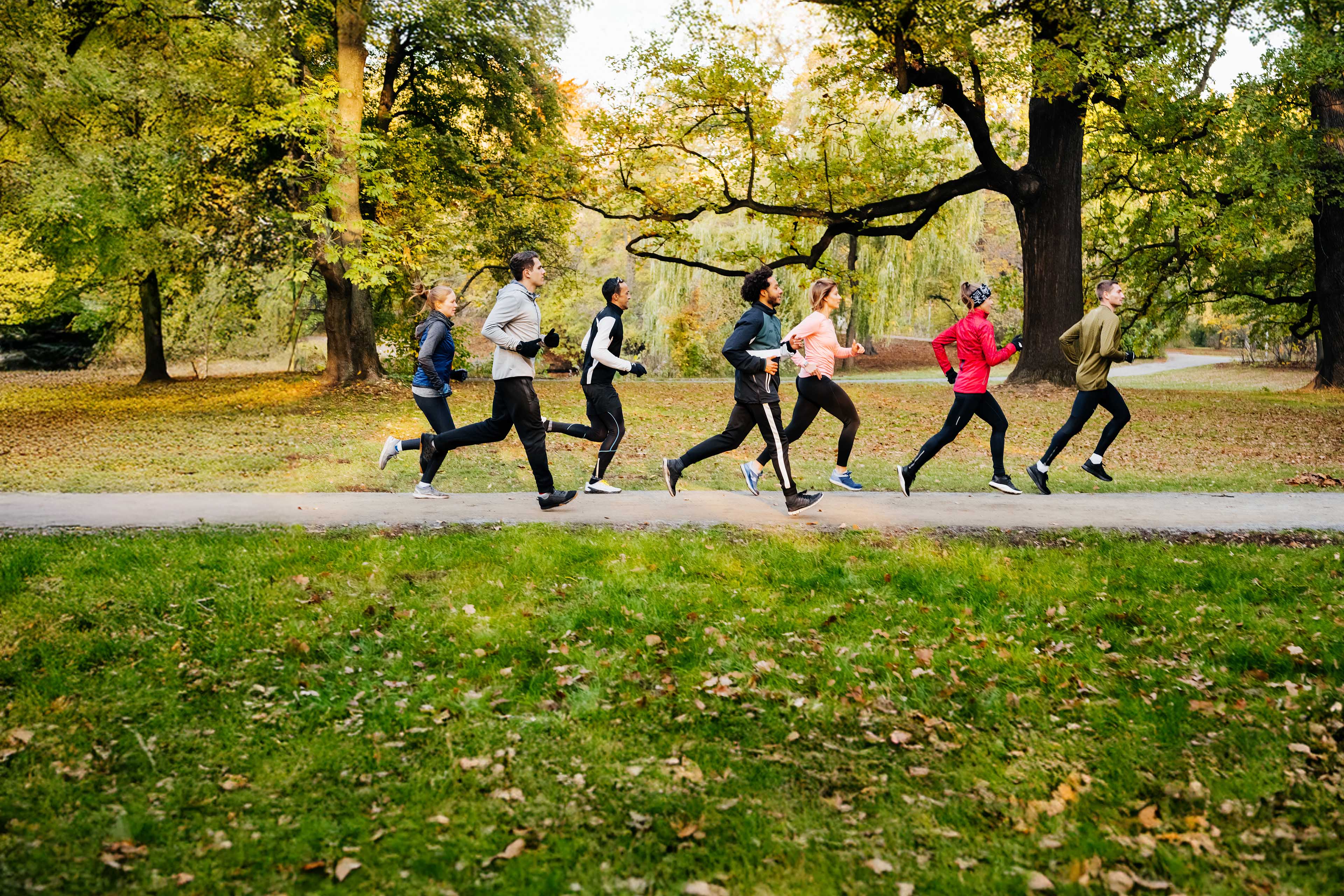 A group of runners racing through the park