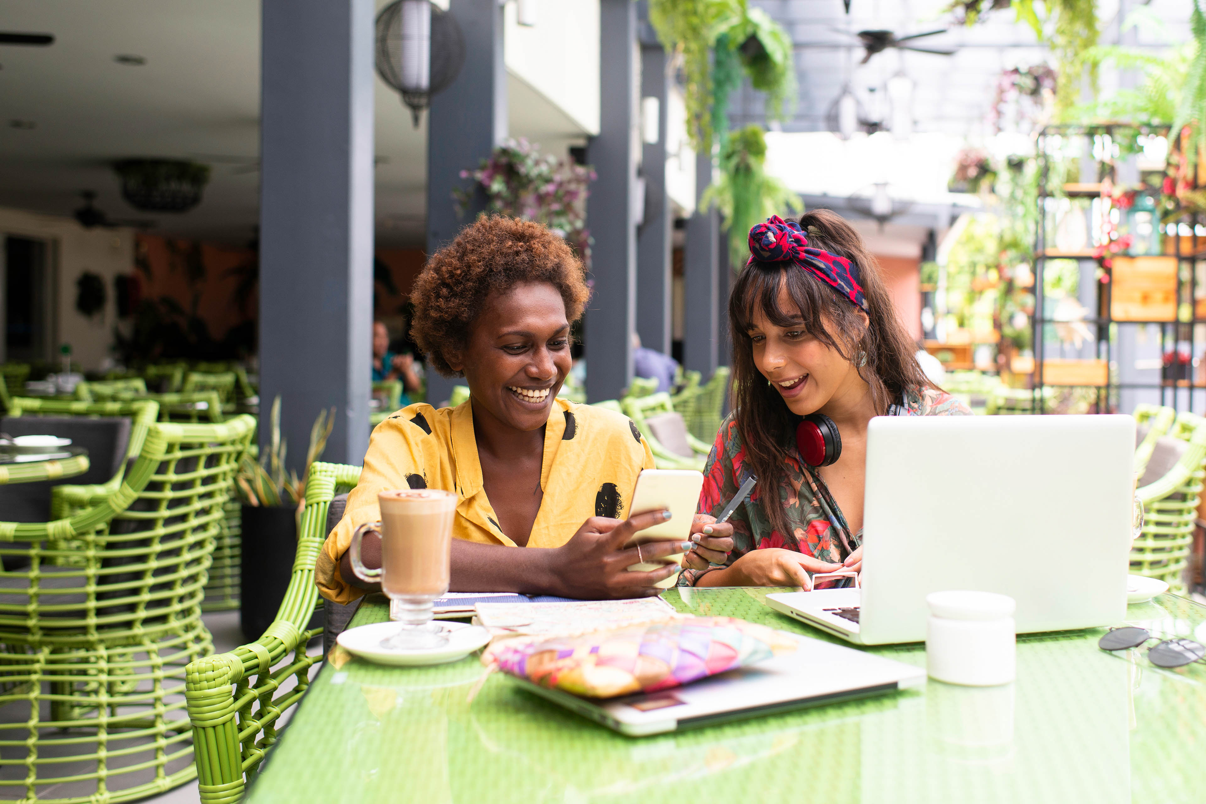 Female couple at a cafe looking at laptop