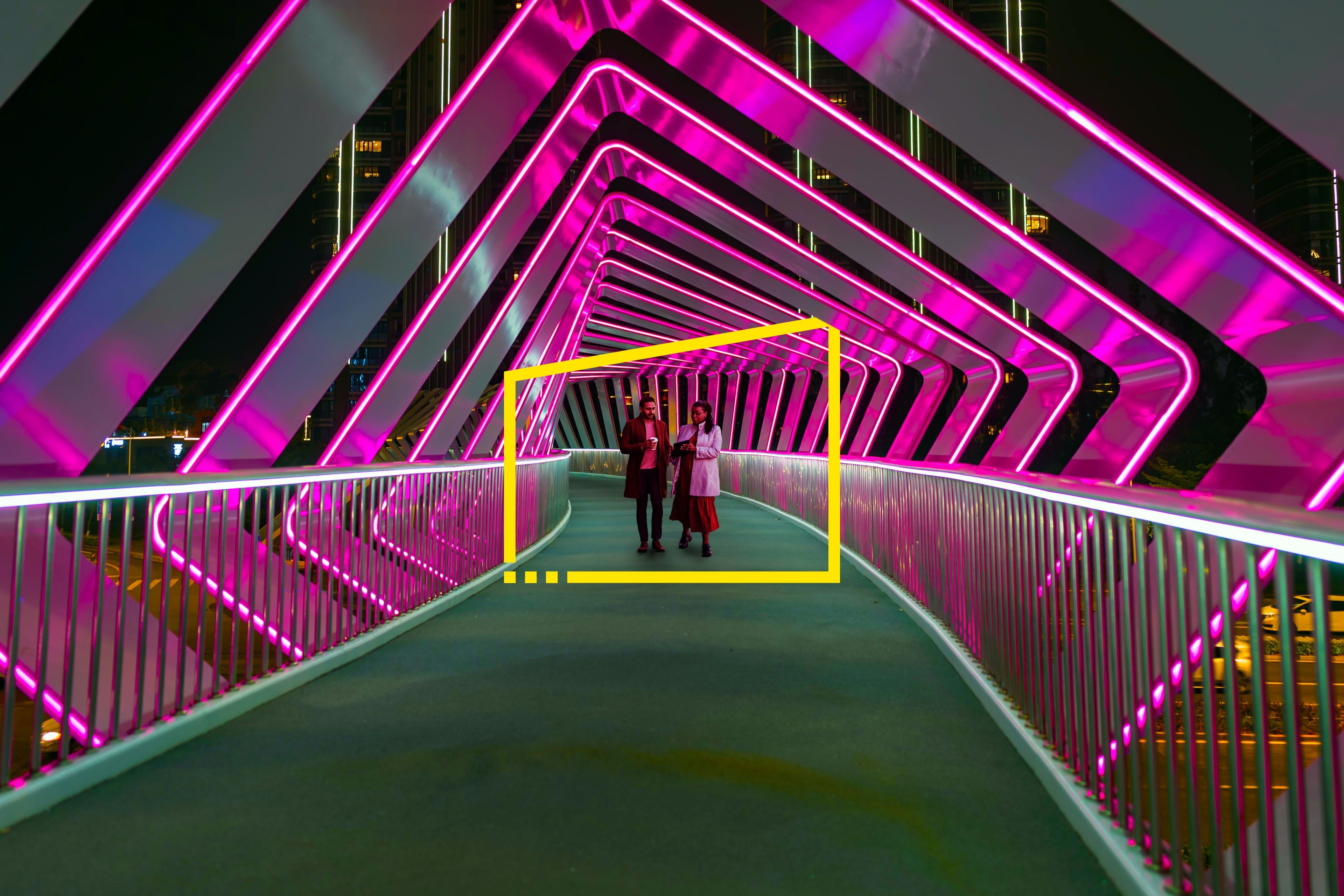 Two people walk along a pink pedestrian bridge at Chuanggu Road