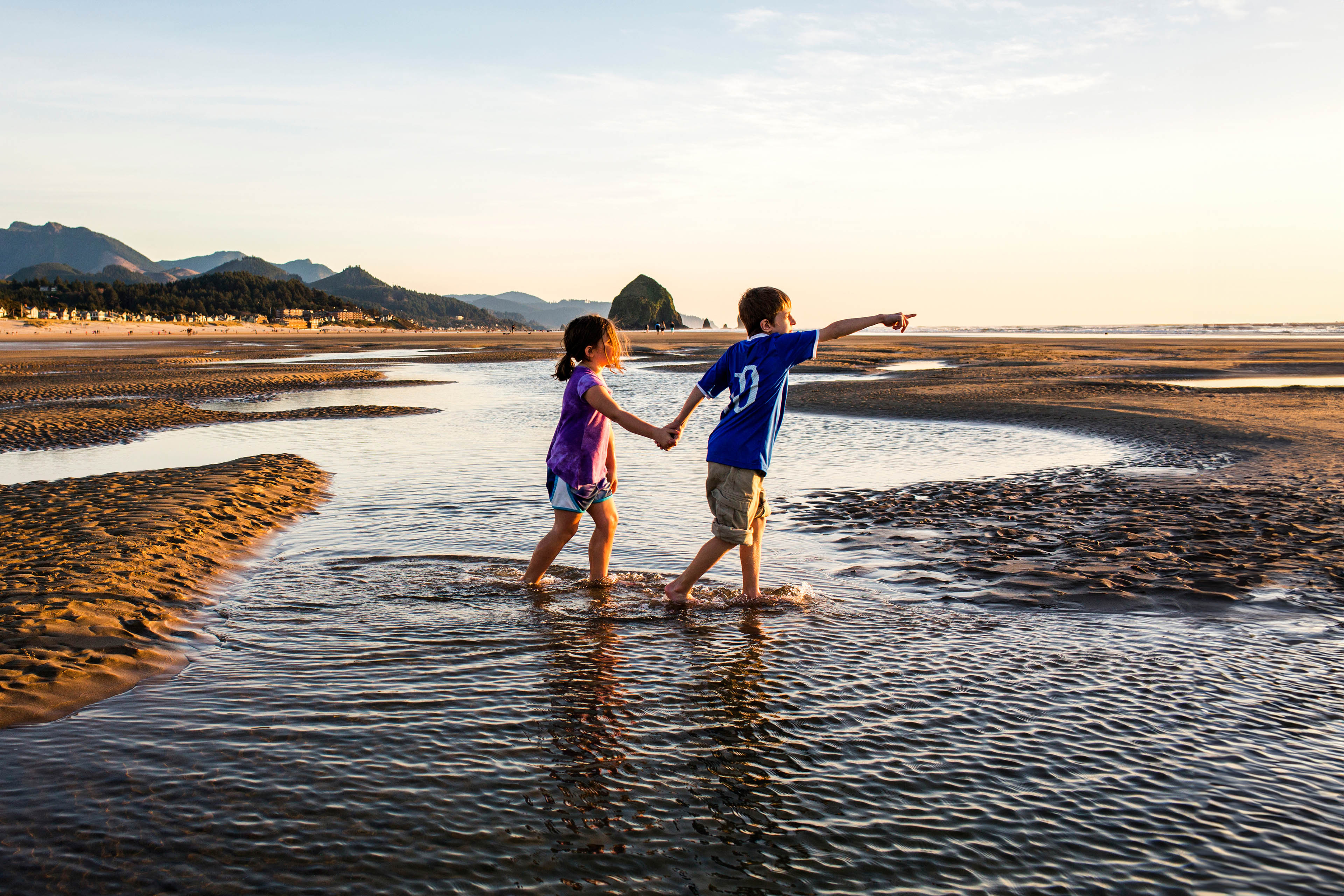 Caucasian children walking in tide pools on beach