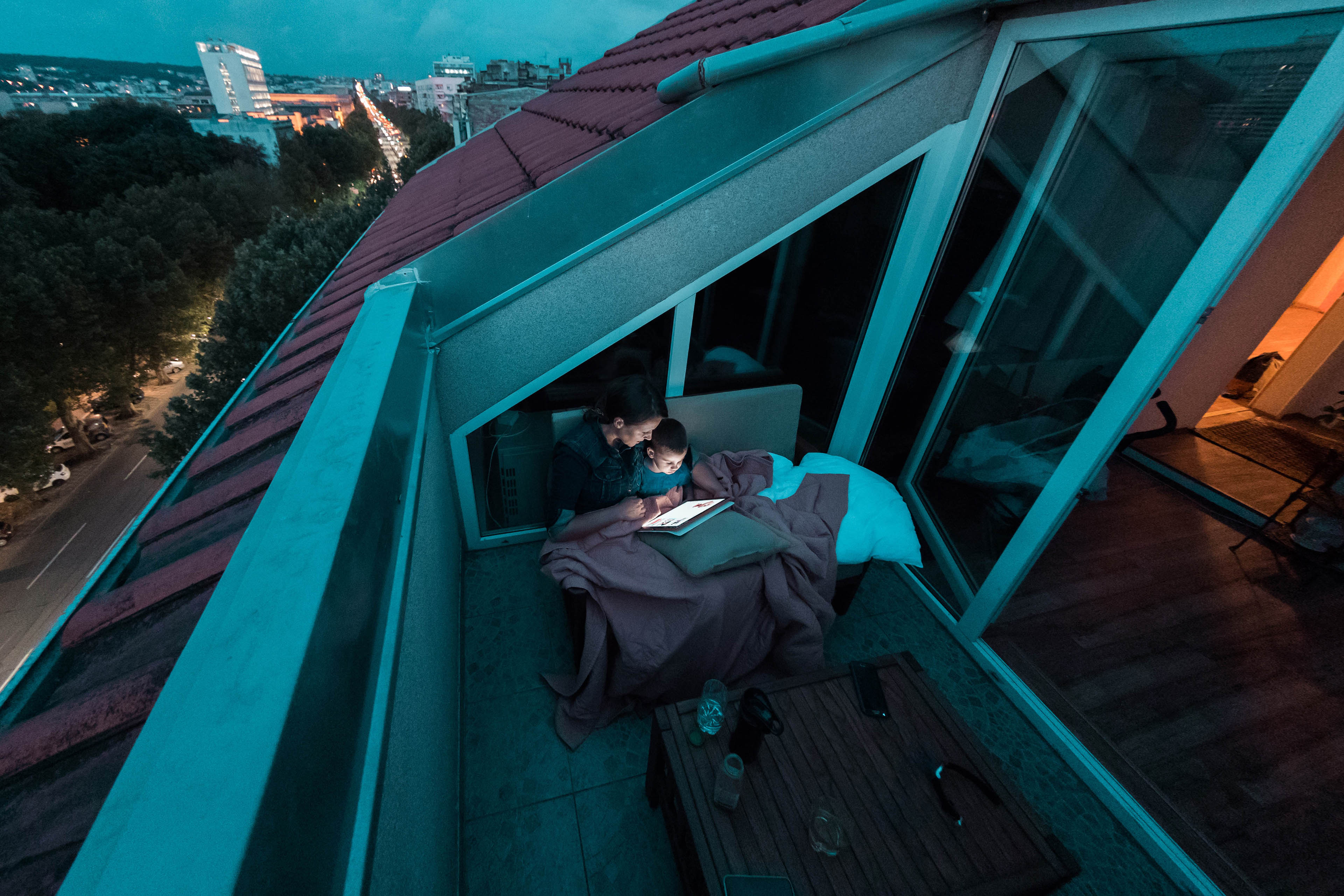 Mother and son reading bedtime stories at the balcony on the e reader