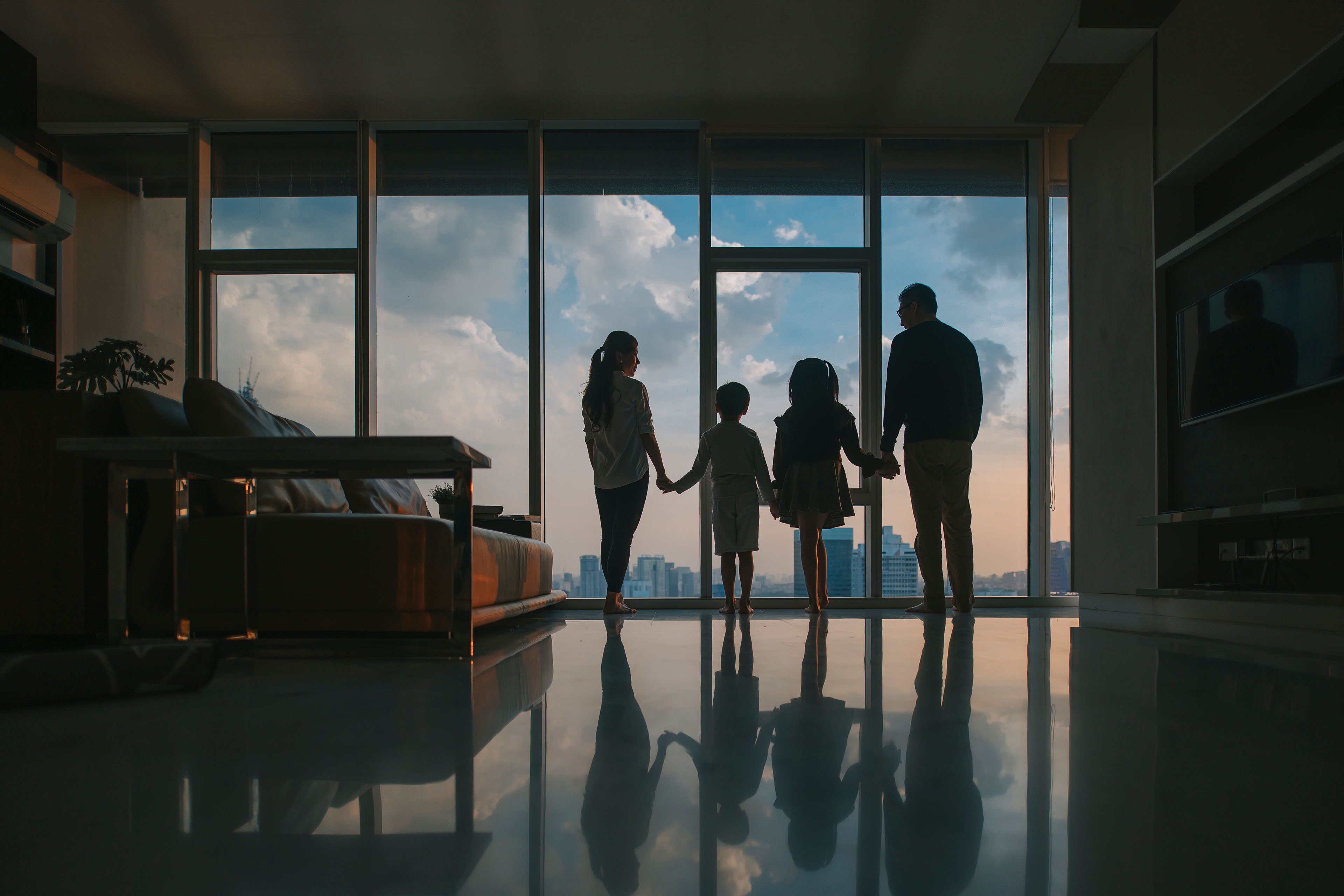 Silhouette rear view asian chinese family with 2 children looking through window