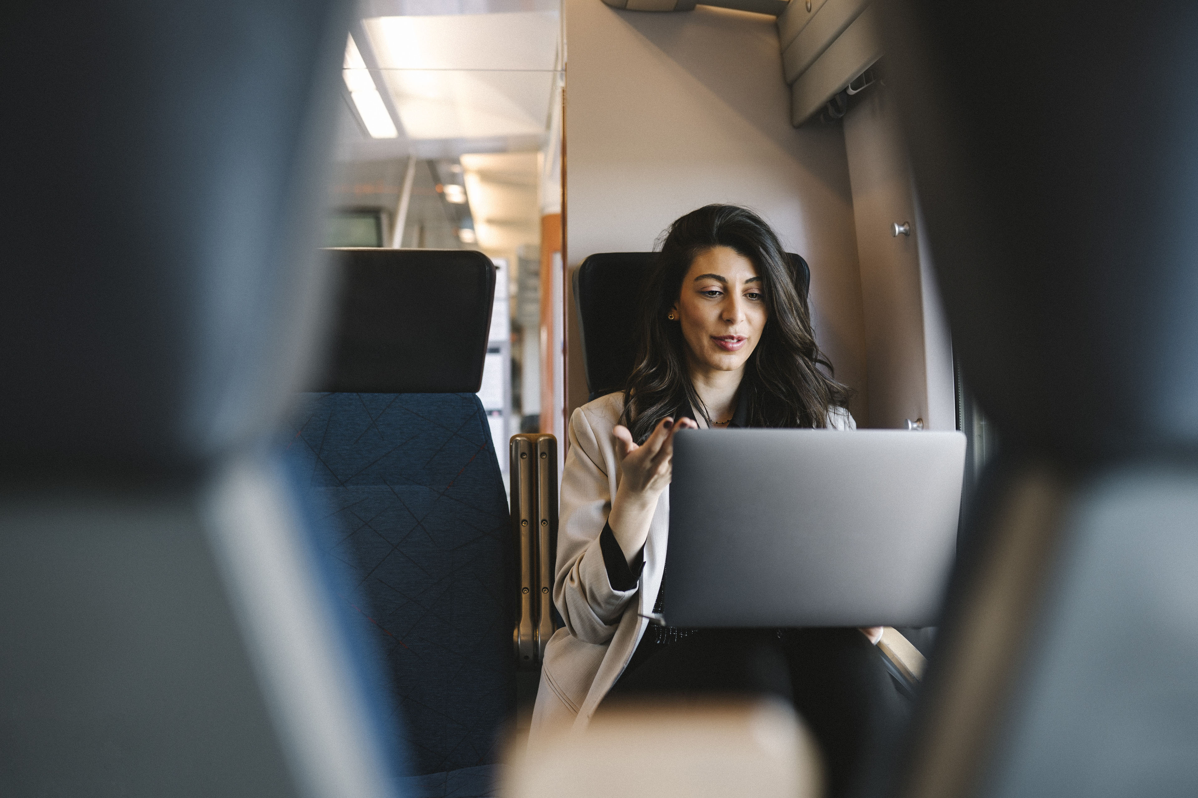 Young woman talking on her laptop on board a train