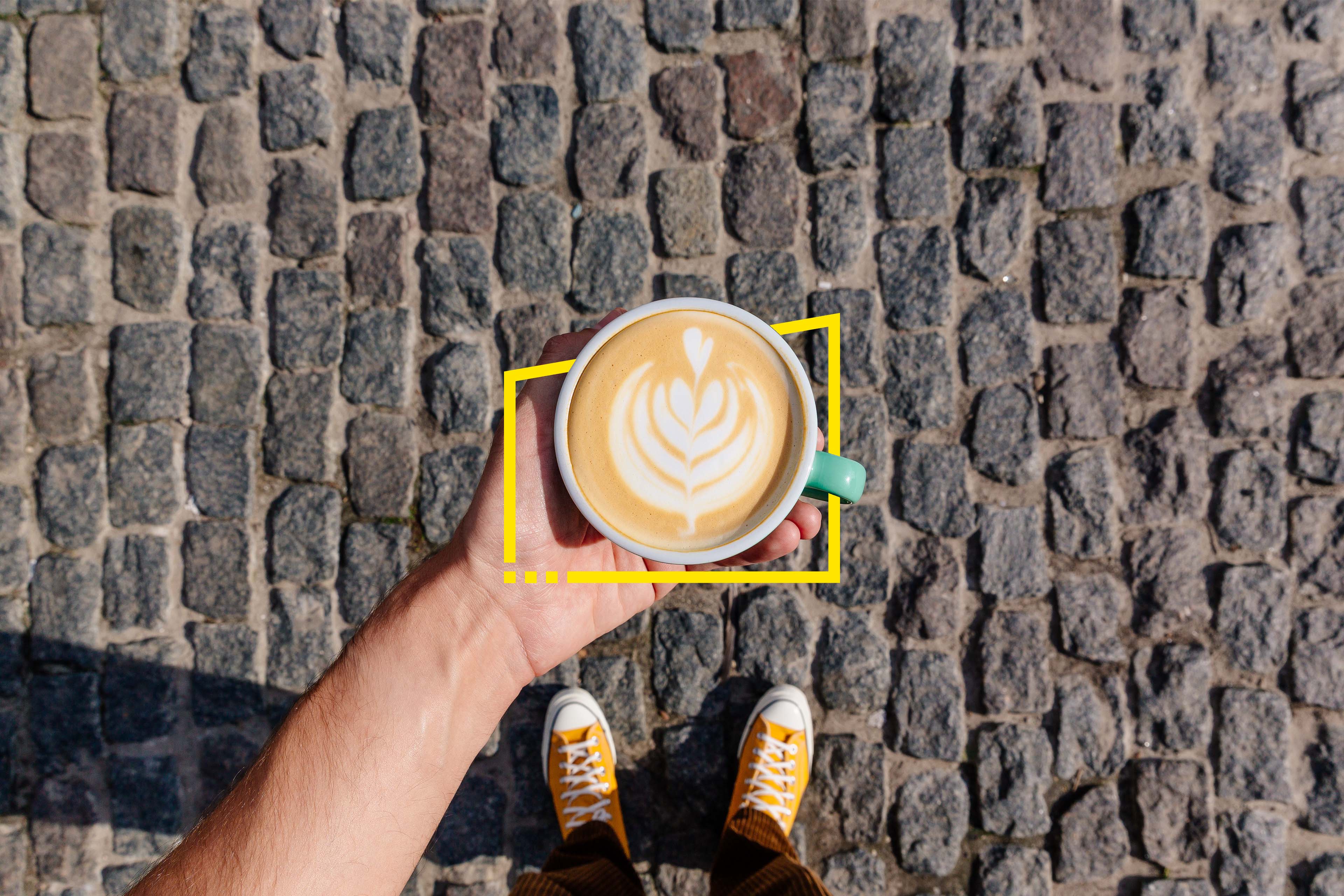 Man holding coffee cup with latte